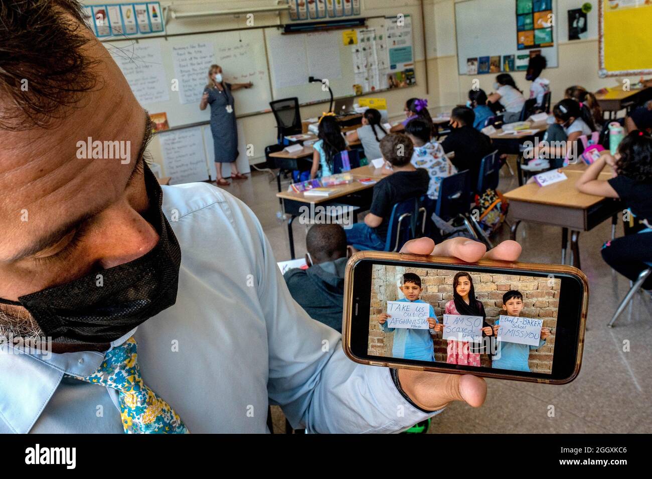 Sacramento, Kalifornien, USA. September 2021. Ethel I. Baker Elementary Principal NATE MCGILL hält sein iPhone und zeigt ein Foto, das ihm von gestrandeten Schulkindern in Kabul in einem ihrer Klassenräume geschickt wurde, auf dem er darum bittet, am ersten Tag am Donnerstag wieder aus Afghanistan zur Schule gebracht zu werden. Sie fuhren mehrmals zum Flughafen, in der Hoffnung, nach Sacramento zu fliegen, wo sie seit vier Jahren leben, aber ohne Erfolg. (Bild: © Renee C. Byer/Sacramento Bee über ZUMA Press Wire) Stockfoto