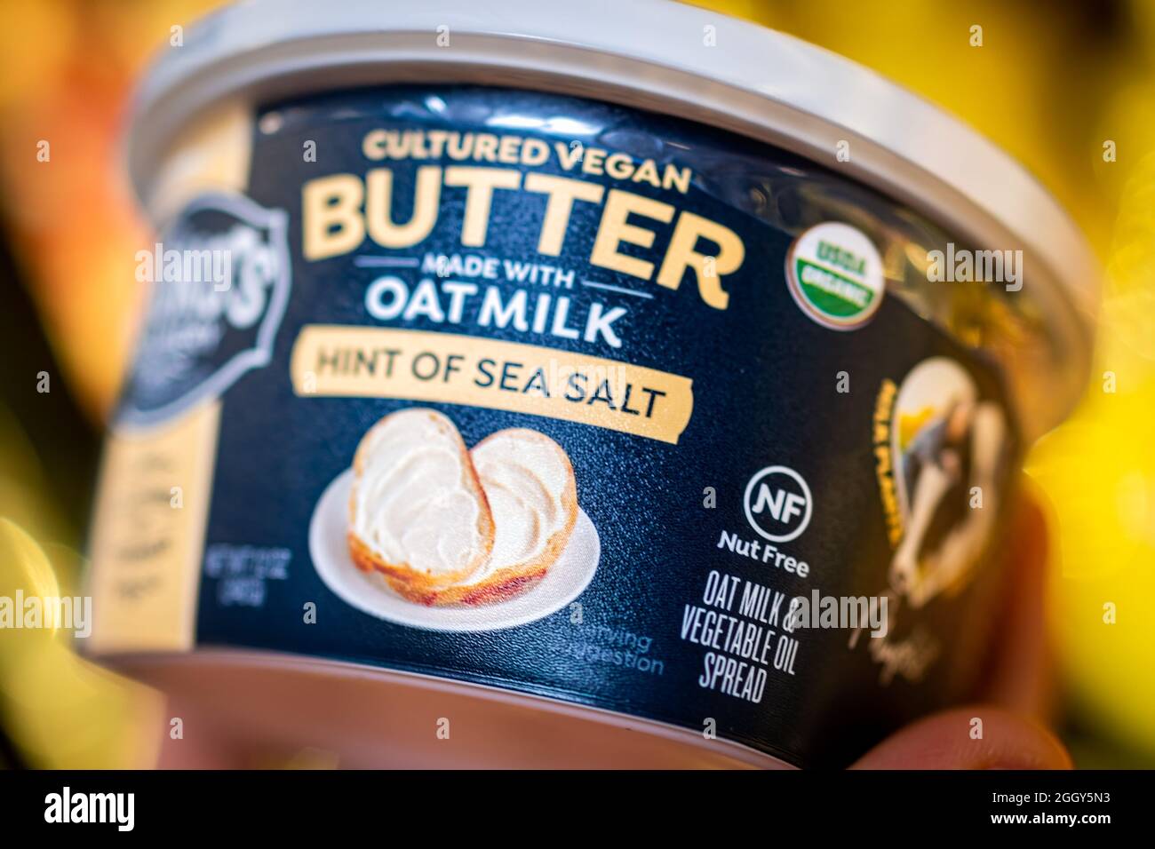 Herndon, USA - 25. März 2021: Nahaufnahme von Hand halten vegane Lebensmittel verpackt Miyoko's Meersalz kultivierte Butter aus Hafermilch, nussfreie Gemüse sp Stockfoto