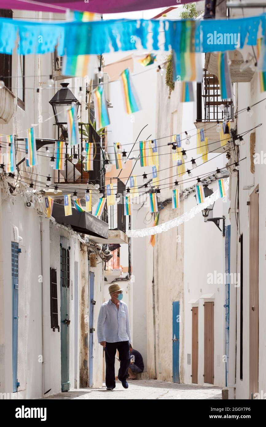 Ein Tourist, der während der Coronavirus-Pandemie eine Gesichtsmaske trägt, erkundet die malerischen Seitenstraßen der Altstadt von Ibiza, Eivissa, den Balearen, Spanien Stockfoto