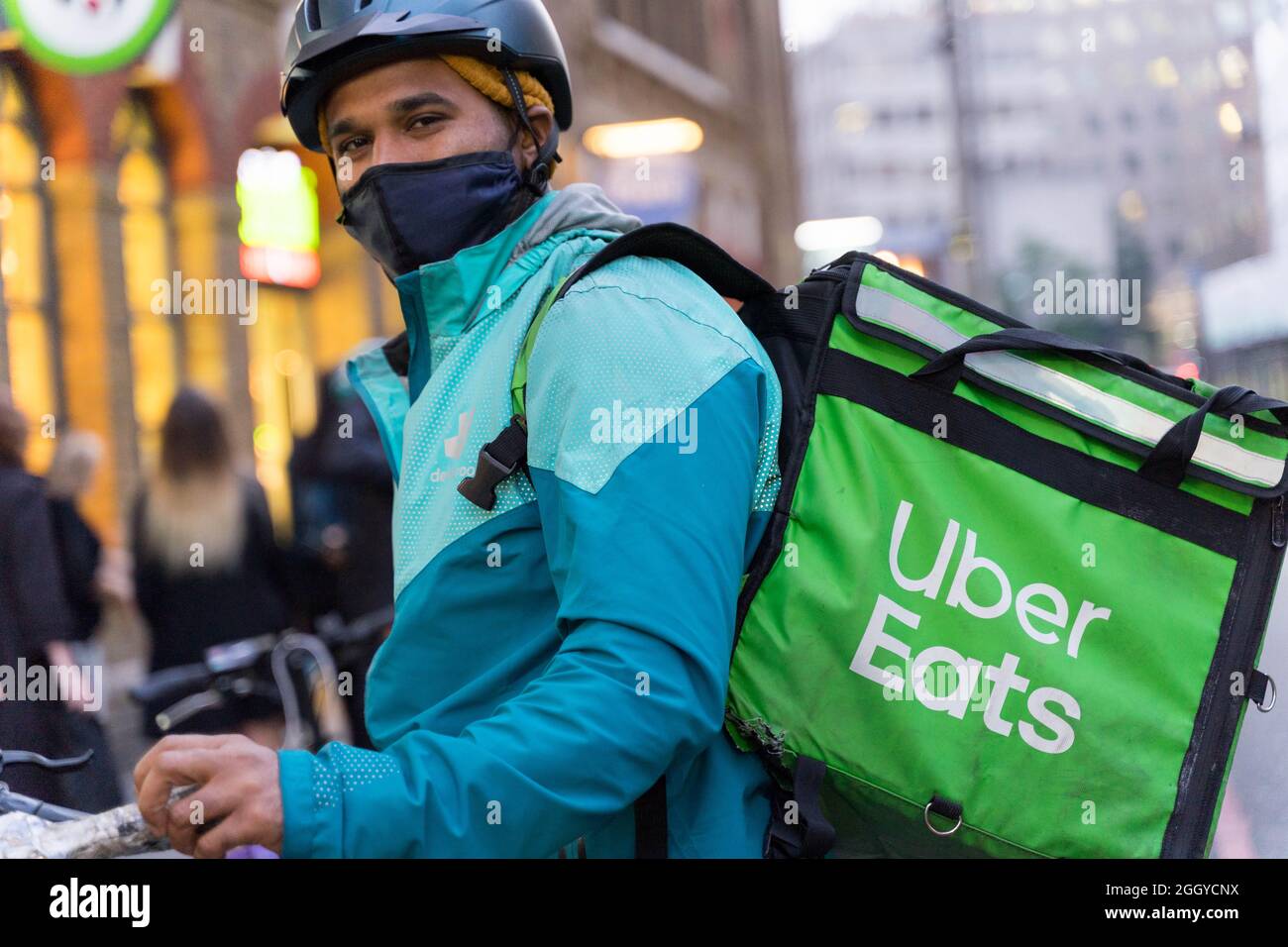 Uber isst Fahrer und seine grüne Hintertasche Stockfoto