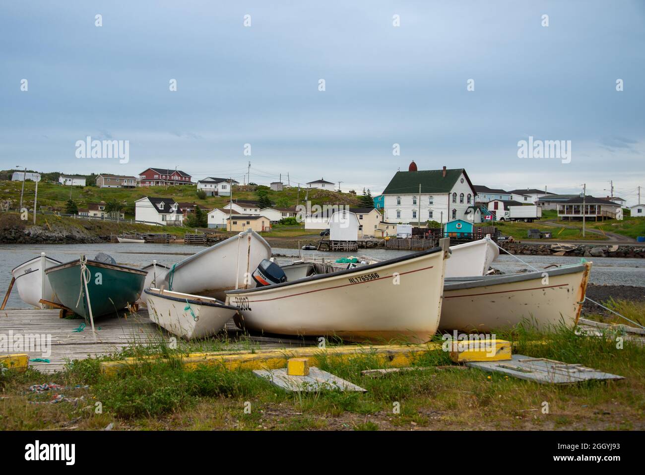 Twillingate, NL, Kanada-August 2021: Die kleine Fischergemeinde Twillingate, Neufundland, mit kleinen weißen Fischerbooten auf einer Holzrutsche. Stockfoto