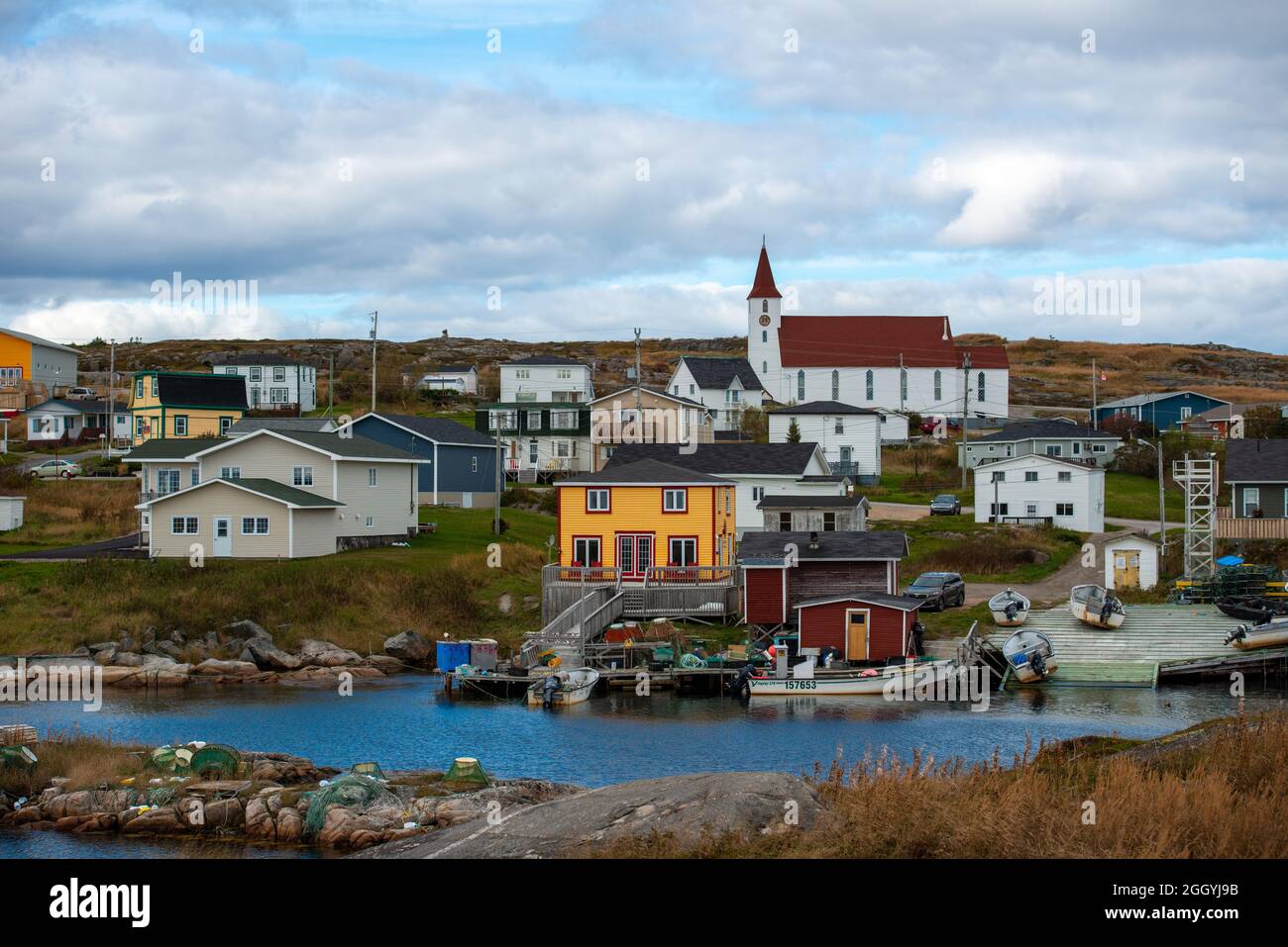 Twillingate, NL, Kanada-August 2021: Die kleine Fischergemeinde Twillingate, Neufundland, mit kleinen weißen Fischerbooten auf einer Holzrutsche. Stockfoto
