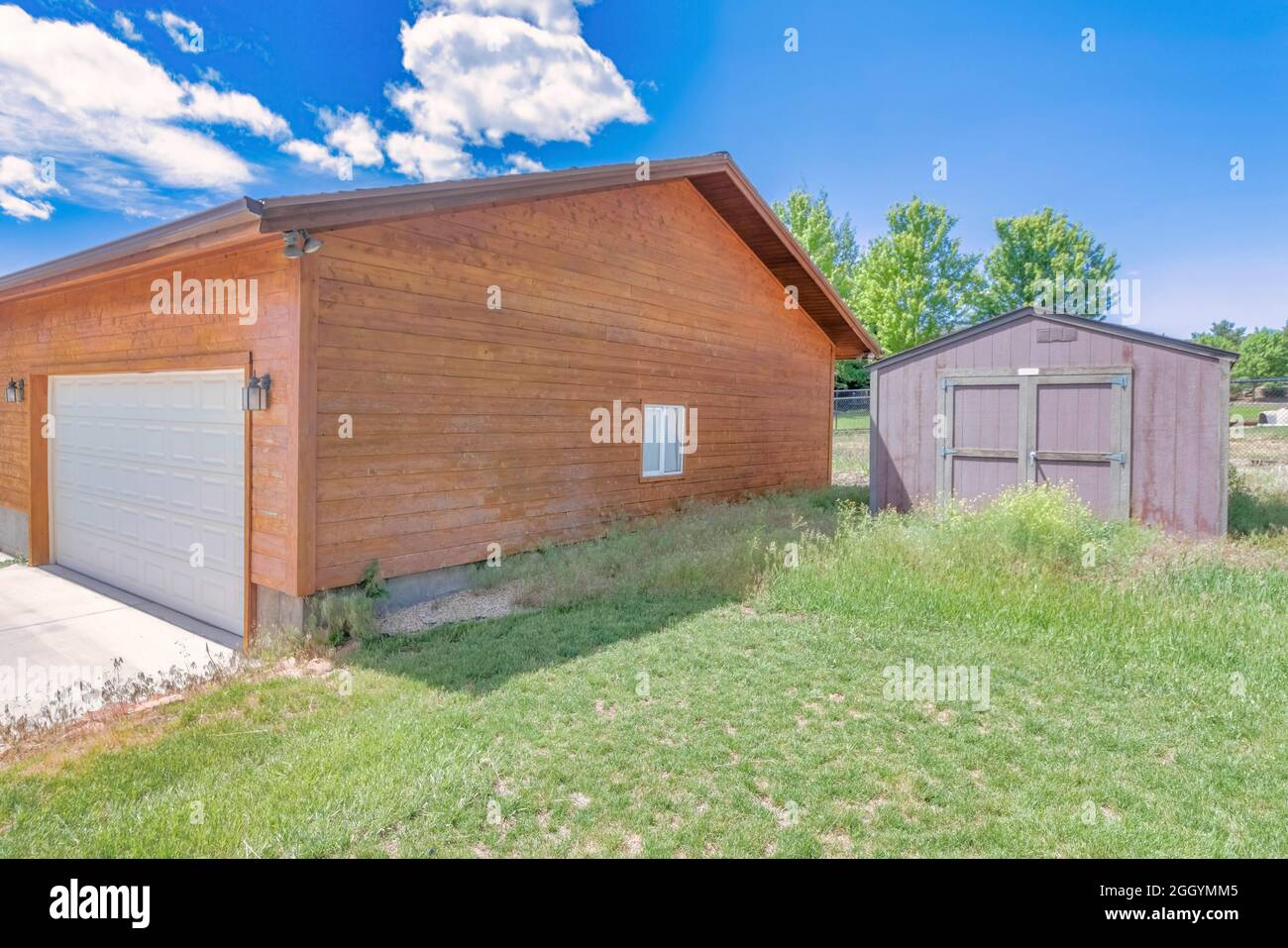 Außenansicht einer Holzgarage und eines Werkzeugschuppens mit Gras Stockfoto