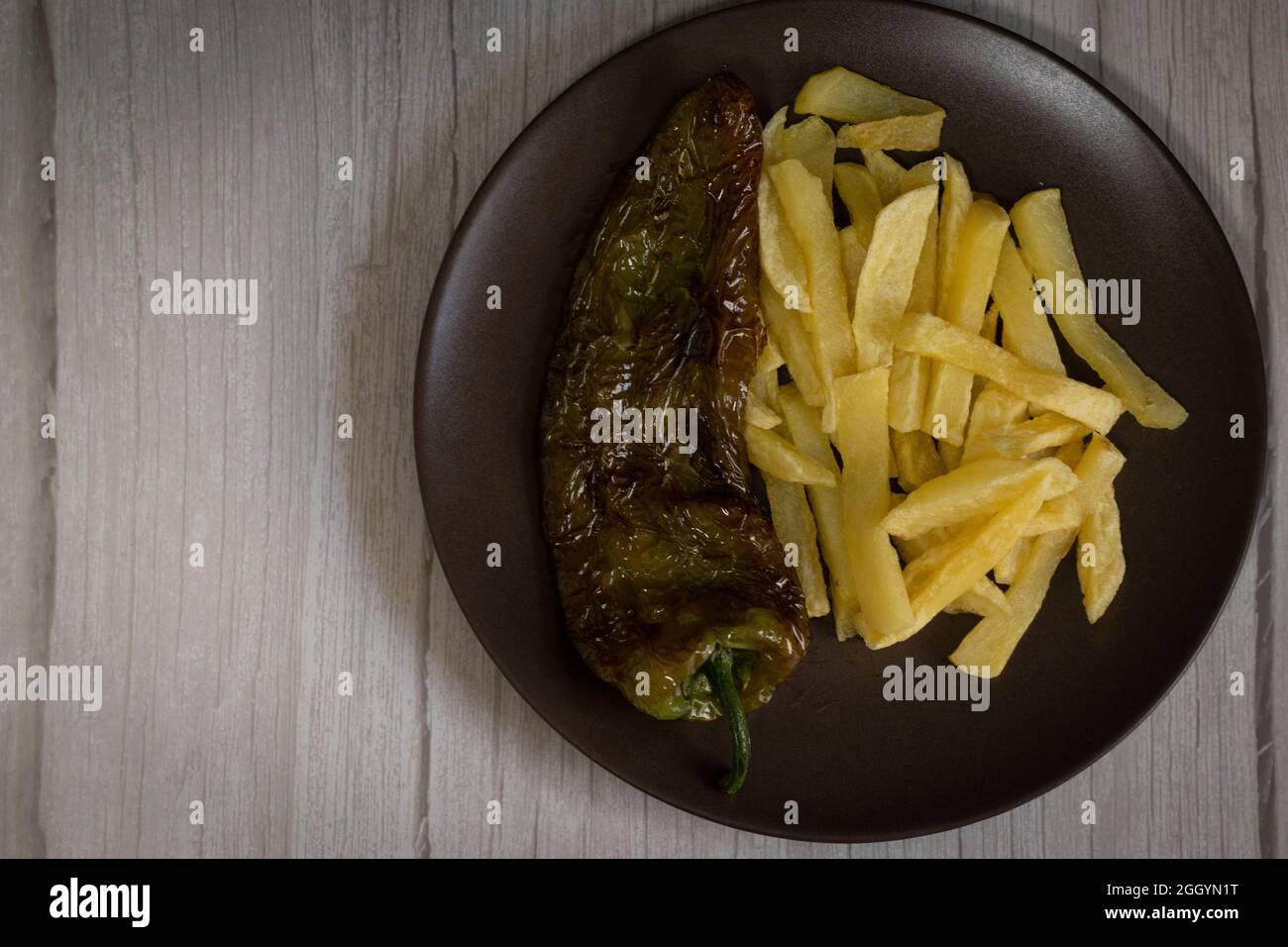 Pommes Frites mit gebratenem Paprika, ein sehr beliebtes Essen in Südspanien. Die Kartoffeln sollten nicht gefroren und alle hausgemacht sein. Alles mit Olivenöl gemacht. Stockfoto