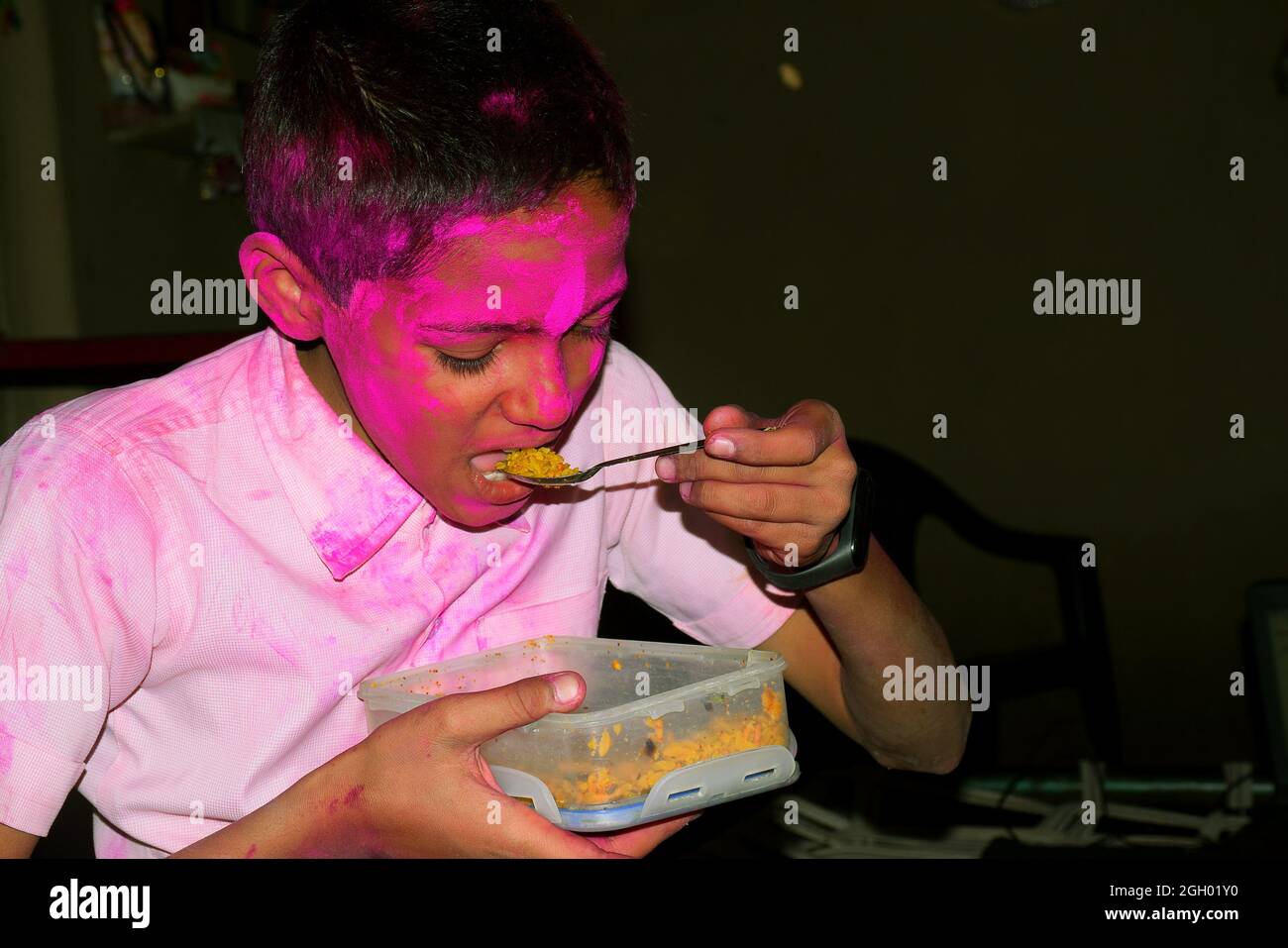 Junge mit buntem Gesicht beim Frühstück. Konzept für das indische Festival Holi Stockfoto