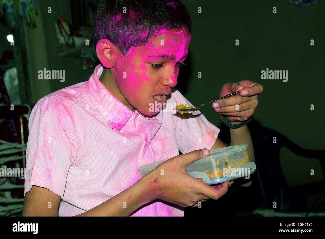 Junge mit buntem Gesicht beim Frühstück. Konzept für das indische Festival Holi Stockfoto