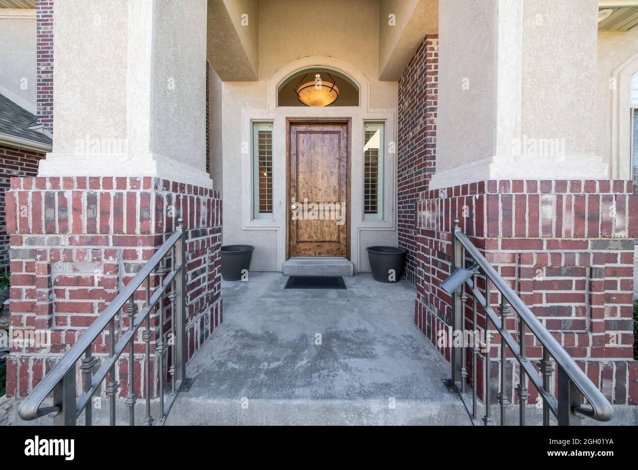 Hölzerne Eingangstür eines Hauses mit zwei Seitenverkleidungen und gewölbtem Heckfenster Stockfoto