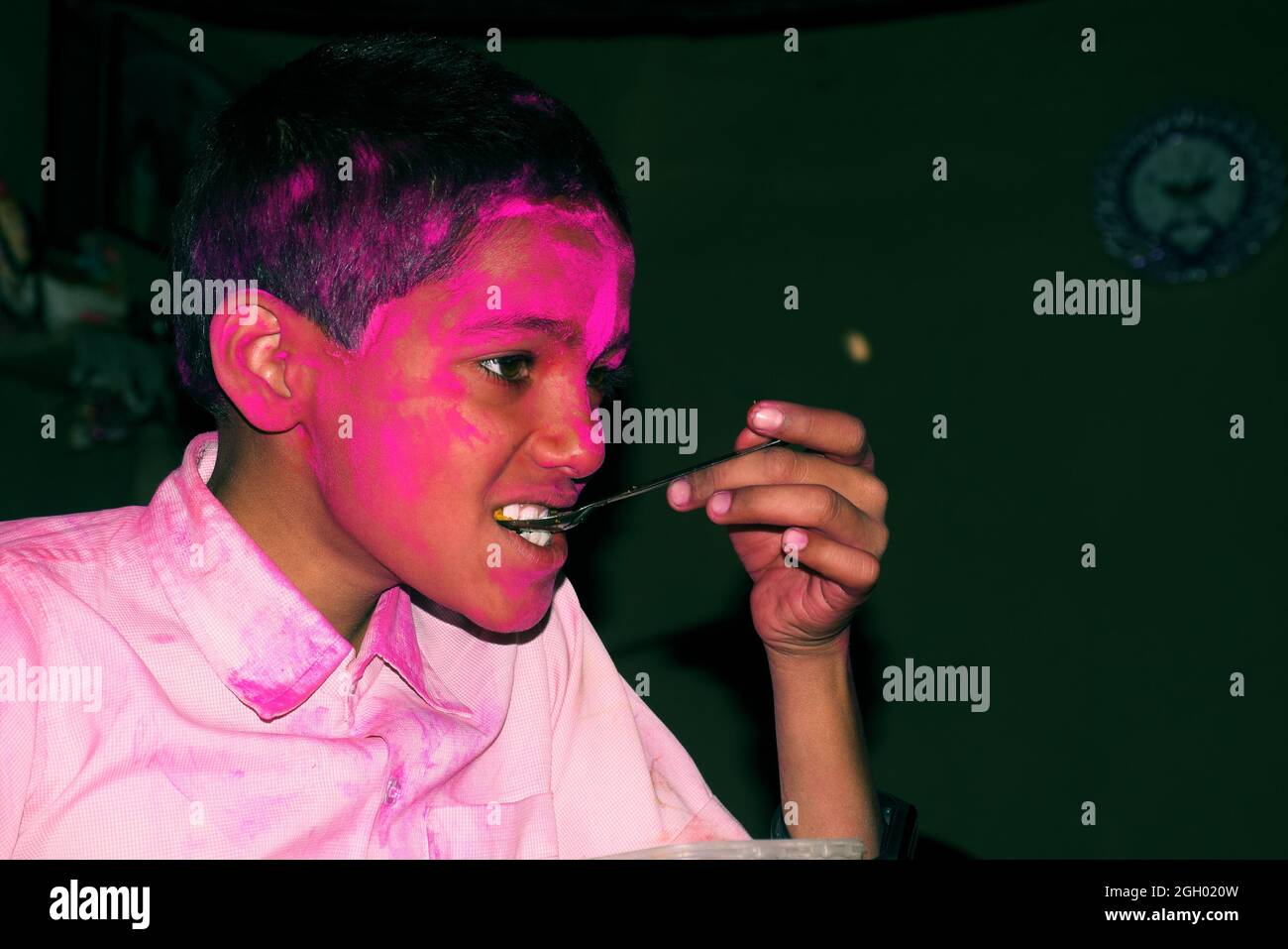 Junge mit buntem Gesicht beim Frühstück. Konzept für das indische Festival Holi Stockfoto