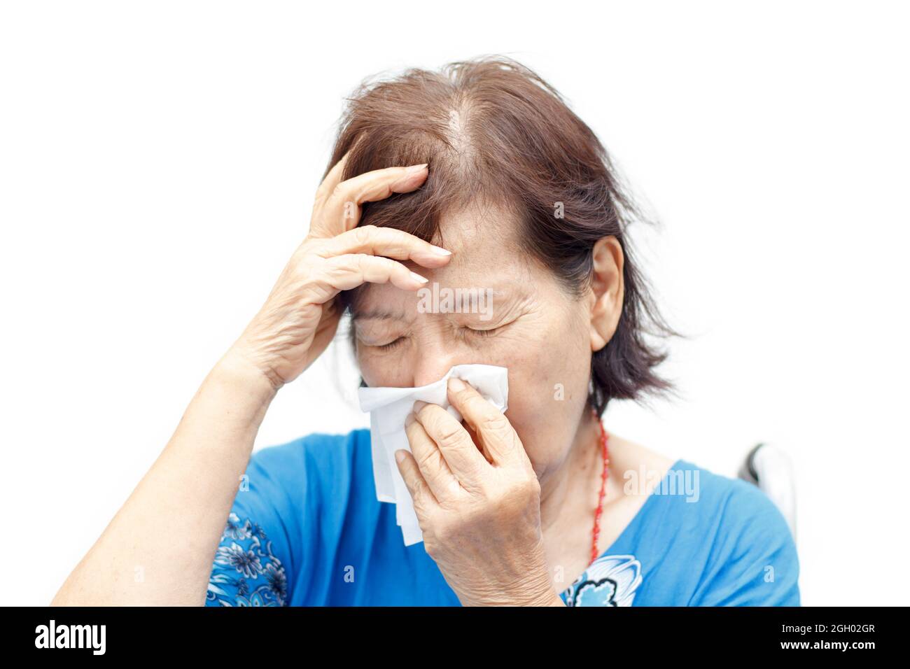 asiatische ältere Frau, die an Kopfschmerzen und Erkältung leidet Stockfoto