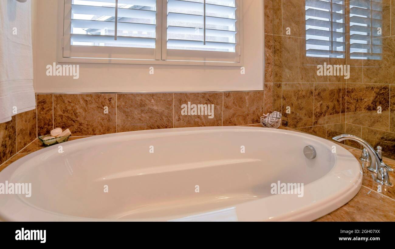 Pano-Badezimmer mit warmem Blitz, Badewanne, Duschkopf und Jalousie-Fenstern  Stockfotografie - Alamy