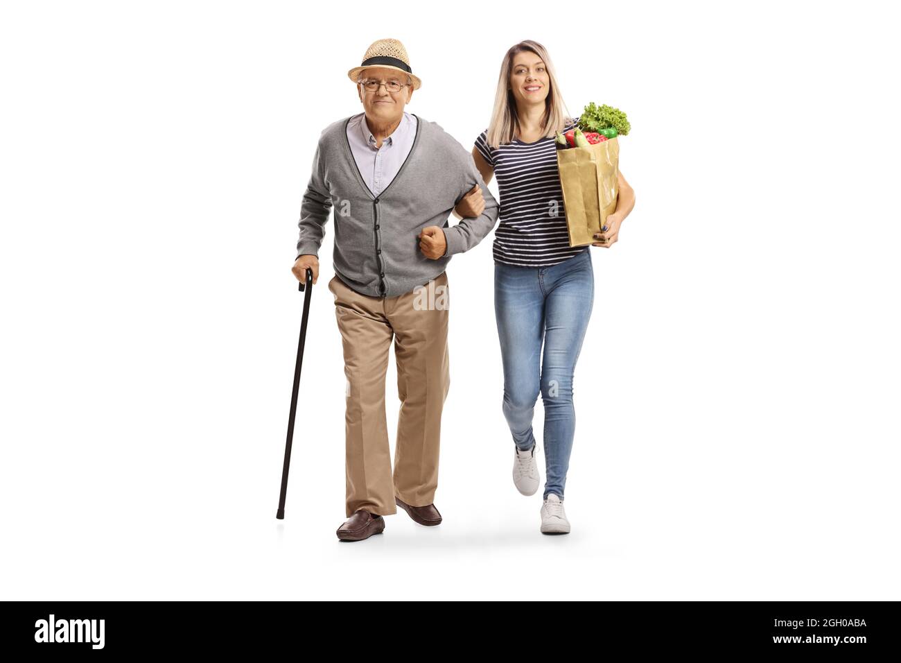 In voller Länge Porträt einer jungen Frau, die eine Lebensmitteltasche trägt und einem älteren Mann hilft, isoliert auf weißem Hintergrund Stockfoto