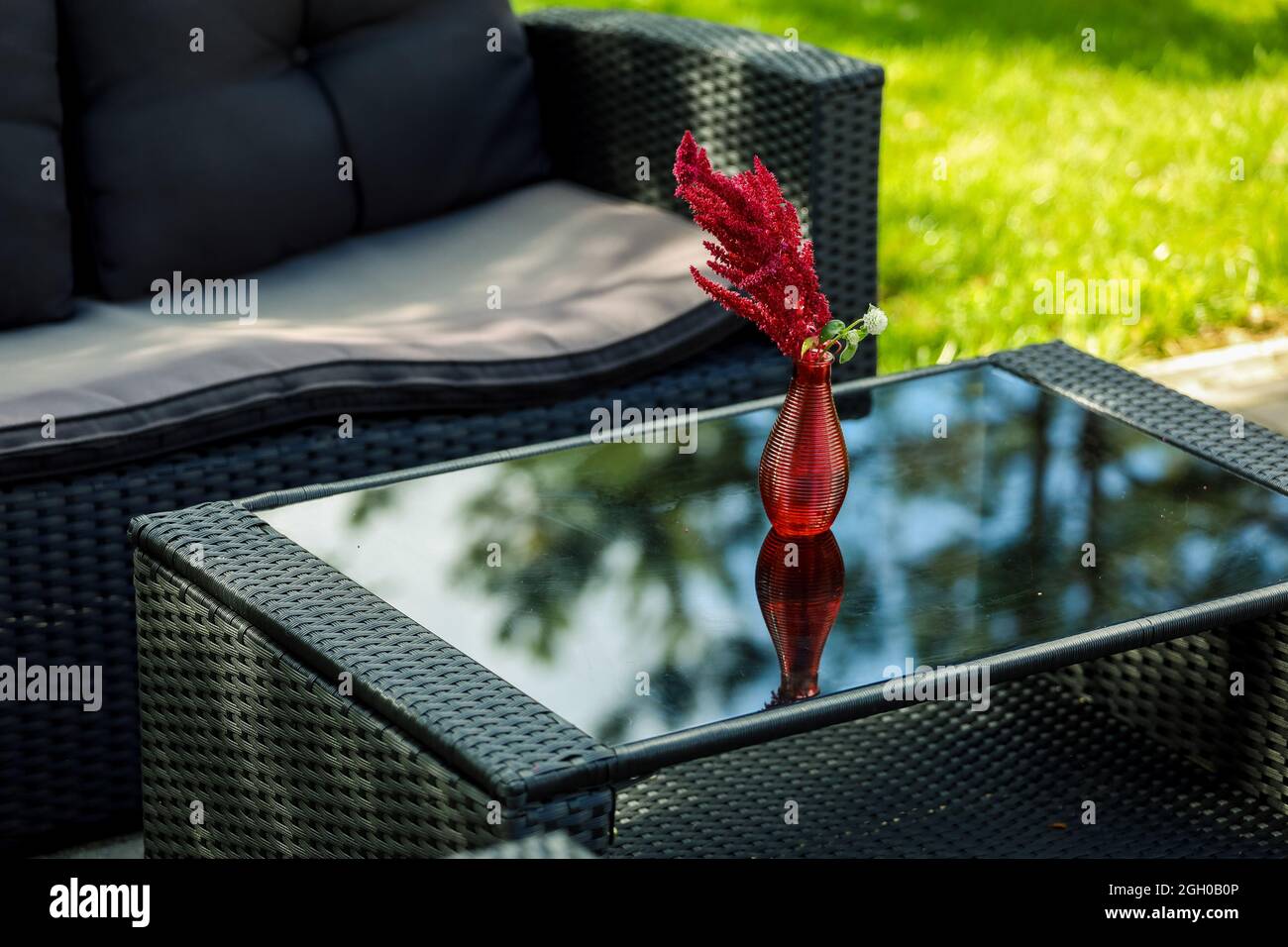 Sitzecke, Sofa, Couchtisch, rote Vase mit einer Blume. Hochwertige Fotos Stockfoto