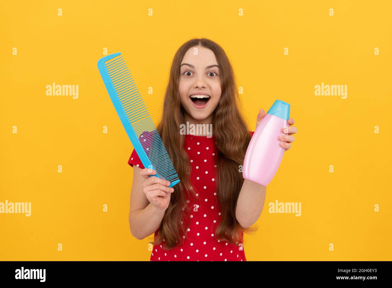 Stauned teen girl hat lange Haare halten Haarbürste und Lotion, selektive Fokus, tägliche Gewohnheit. Stockfoto