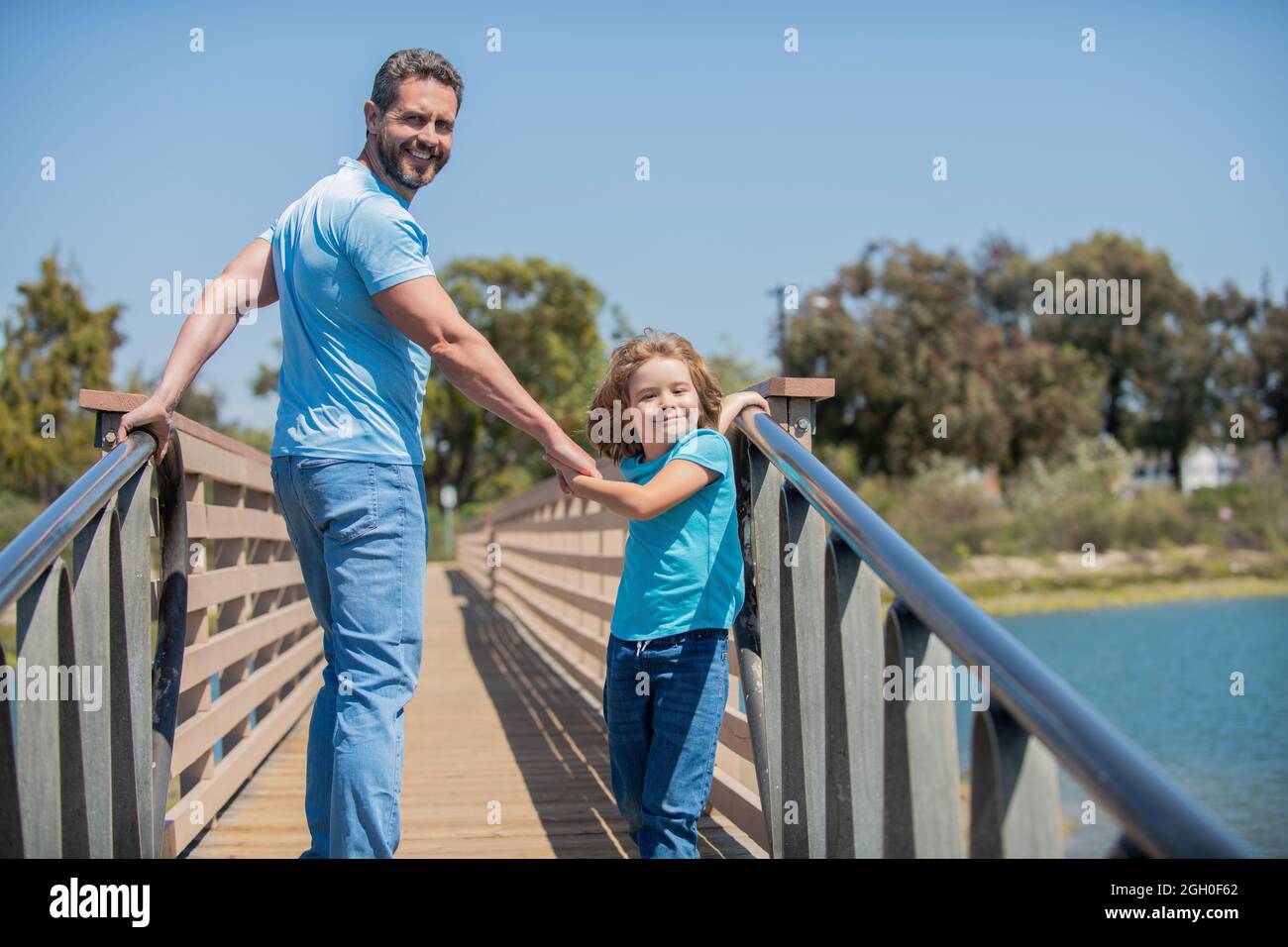 Glücklicher Vater, der Spaß mit seinem Sohn hat, der im Sommer draußen läuft Stockfoto