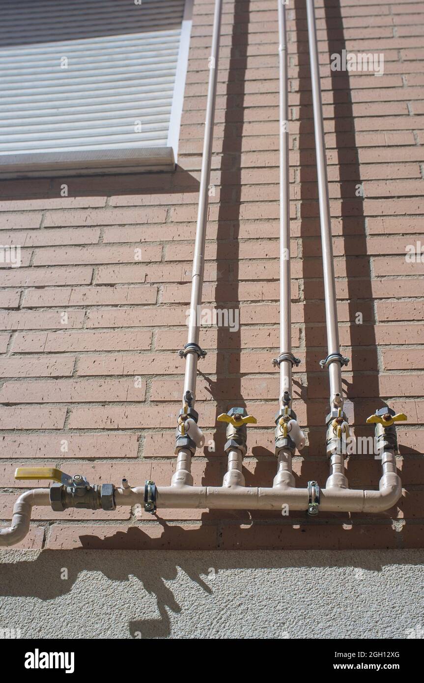 An das Außengebäude angeschlossene Erdgasleitungen für den Hausgebrauch. Selektiver Fokus auf Verbindungen. Stockfoto