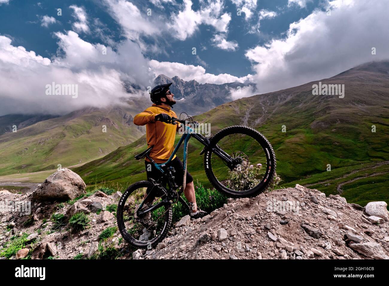 Elbrus, Kabardino-Balkarien, Russland - August 2021: Mountainbiken in Elbrus. Radfahrer auf einem Hügel und genießen den Blick auf die Berge. MTB-Bicy Stockfoto