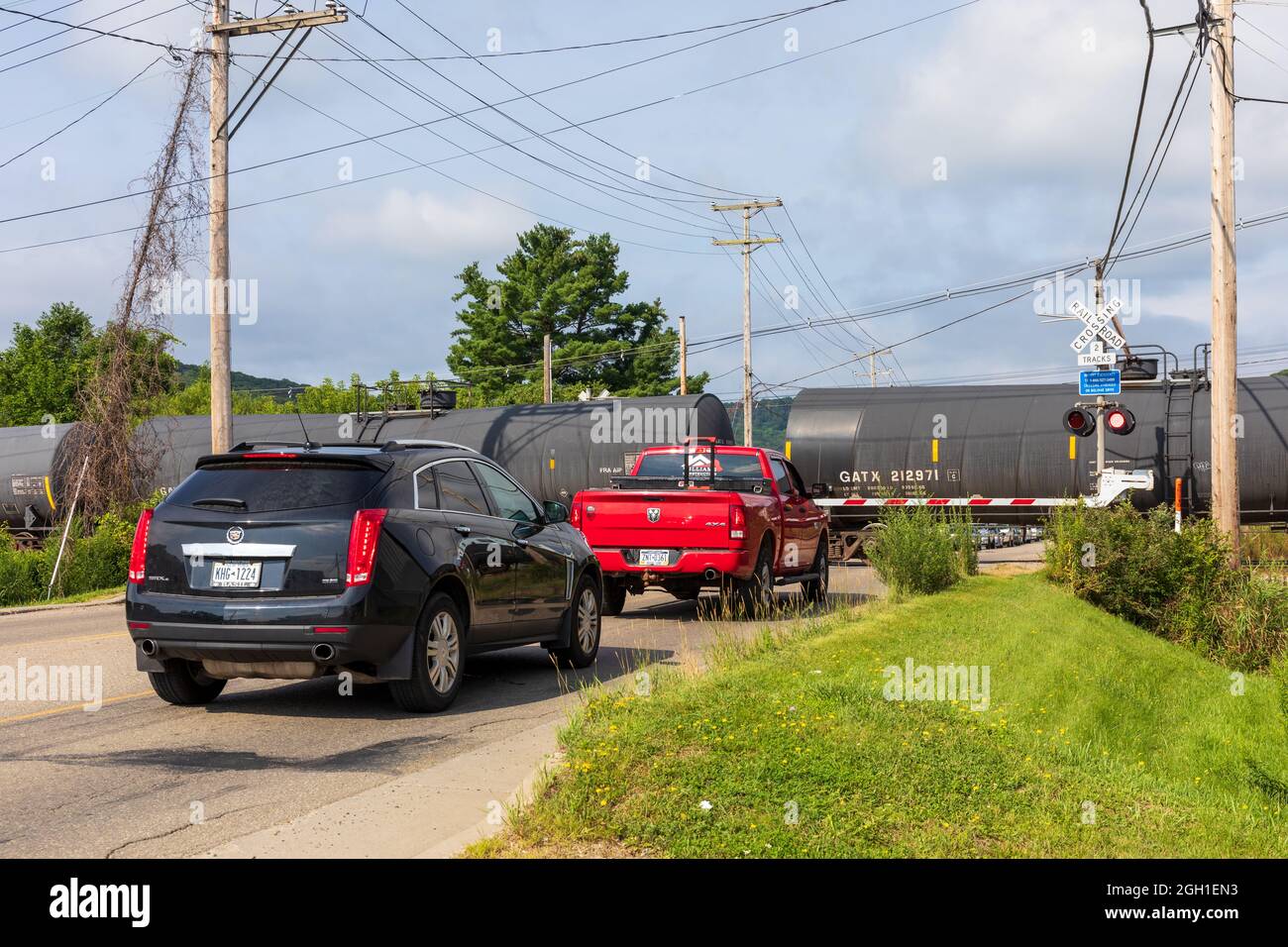 BRADFORD, PA, USA-13. AUGUST 2021: Autos hielten an einem Bahnübergang. Stockfoto