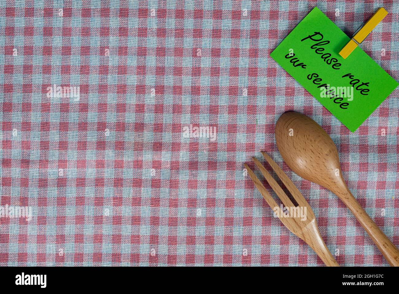 Geschäftskonzept. Layout von Flanell Tischtuch, Holzgabel und Löffel, Note und Tuch Stift mit Text. Bewertung des Kundenservice. Stockfoto