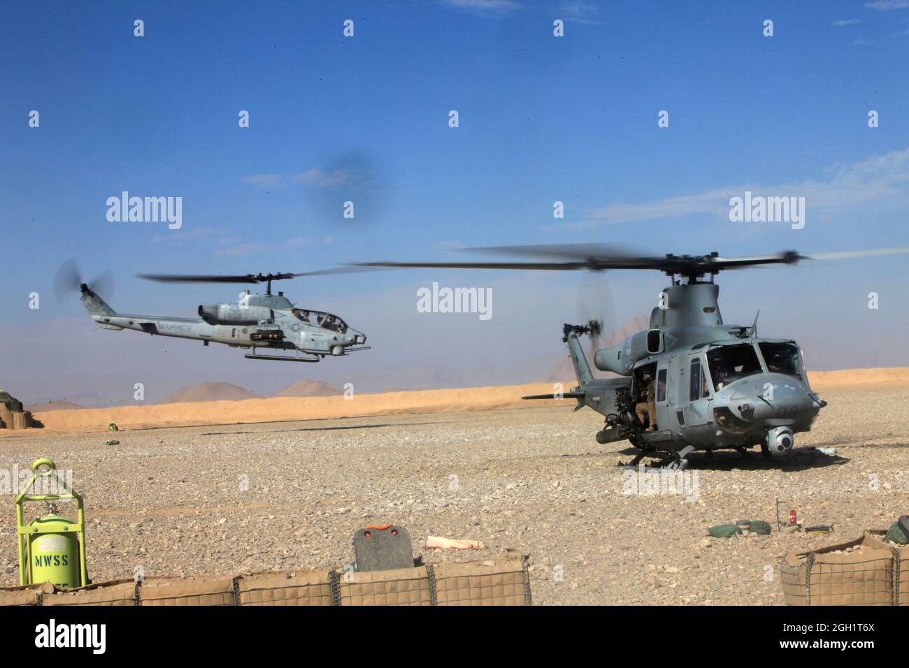 Eine AH-1W Super Cobra fliegt an einer UH-1Y Huey vorbei, da beide Flugzeuge mit Marine Light Attack Helicopter Squadron 369 die Operationsbasis Edinburgh in der Provinz Helmand, Afghanistan, für eine Mission am 1. Januar verlassen. Koalitionskräfte in Afghanistan haben das neue Jahr durch fortgesetzte Operationen zur Aufstandsbekämpfung erreicht. Stockfoto
