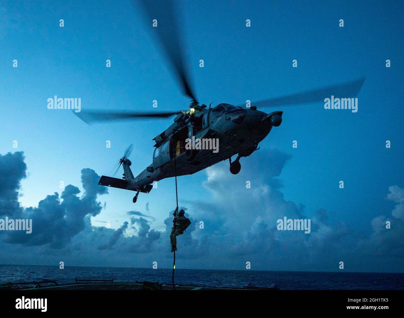 PHILIPPINISCHES MEER (6. Juni 2021) Ein Seemann, der der explosiven Ordnance Disposal Task Force 70 zugewiesen wurde, wurde mit einem an der MH-60S Sea Hawk befestigten Hubschrauber ausgestattet Stockfoto