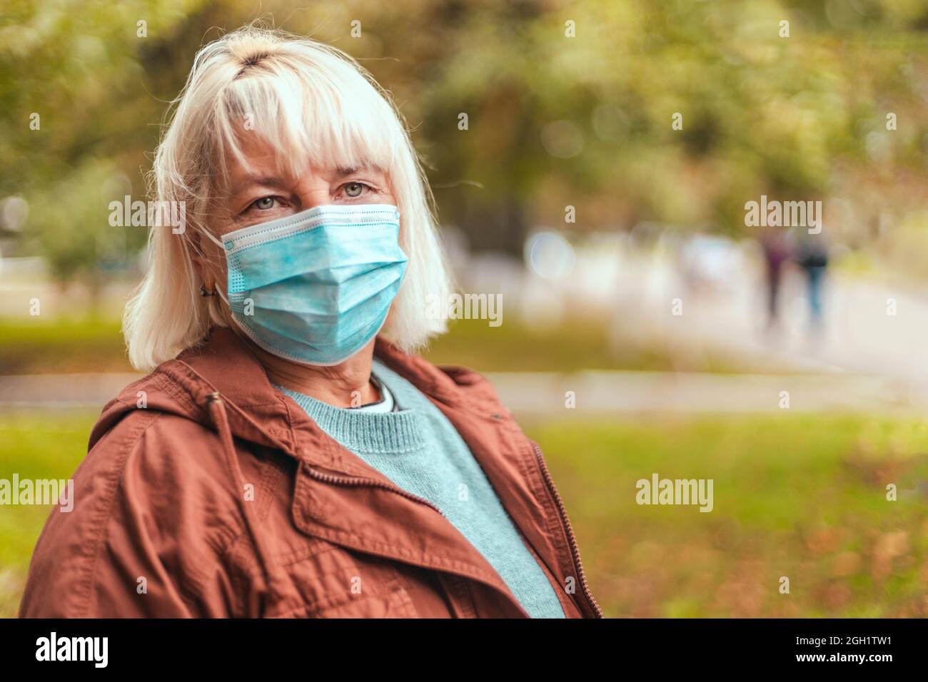 Coronavirus, COVID-19 Pandemiekonzept. Blonde Frau trägt Gesichtsmaske schützend für Krankheit Virus Stockfoto