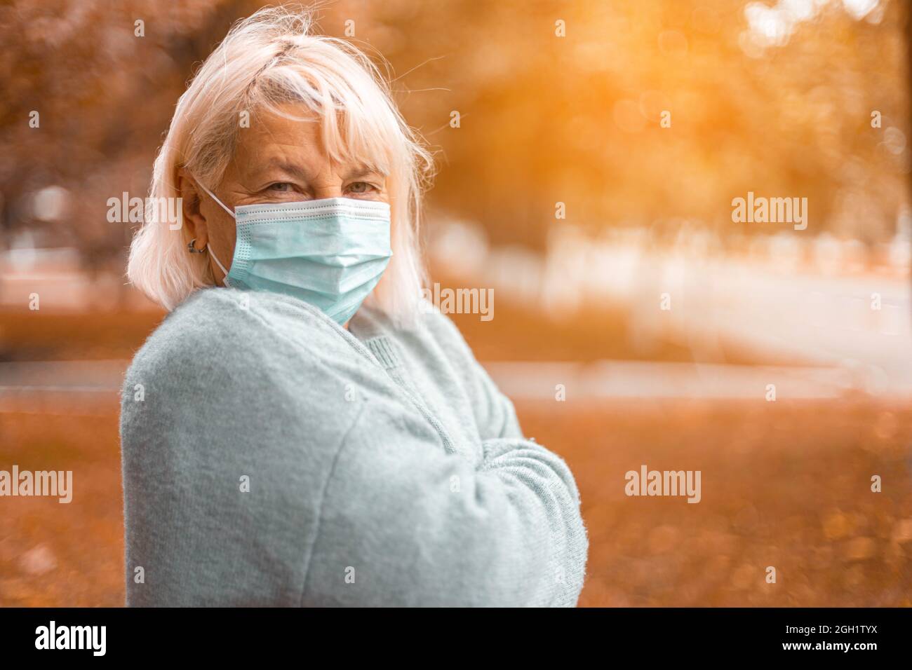 Coronavirus, COVID-19 Pandemiekonzept. Blonde Frau trägt Gesichtsmaske Schutz für Krankheit Virus SARS-CoV-2 an der Straße der Stadt Stockfoto