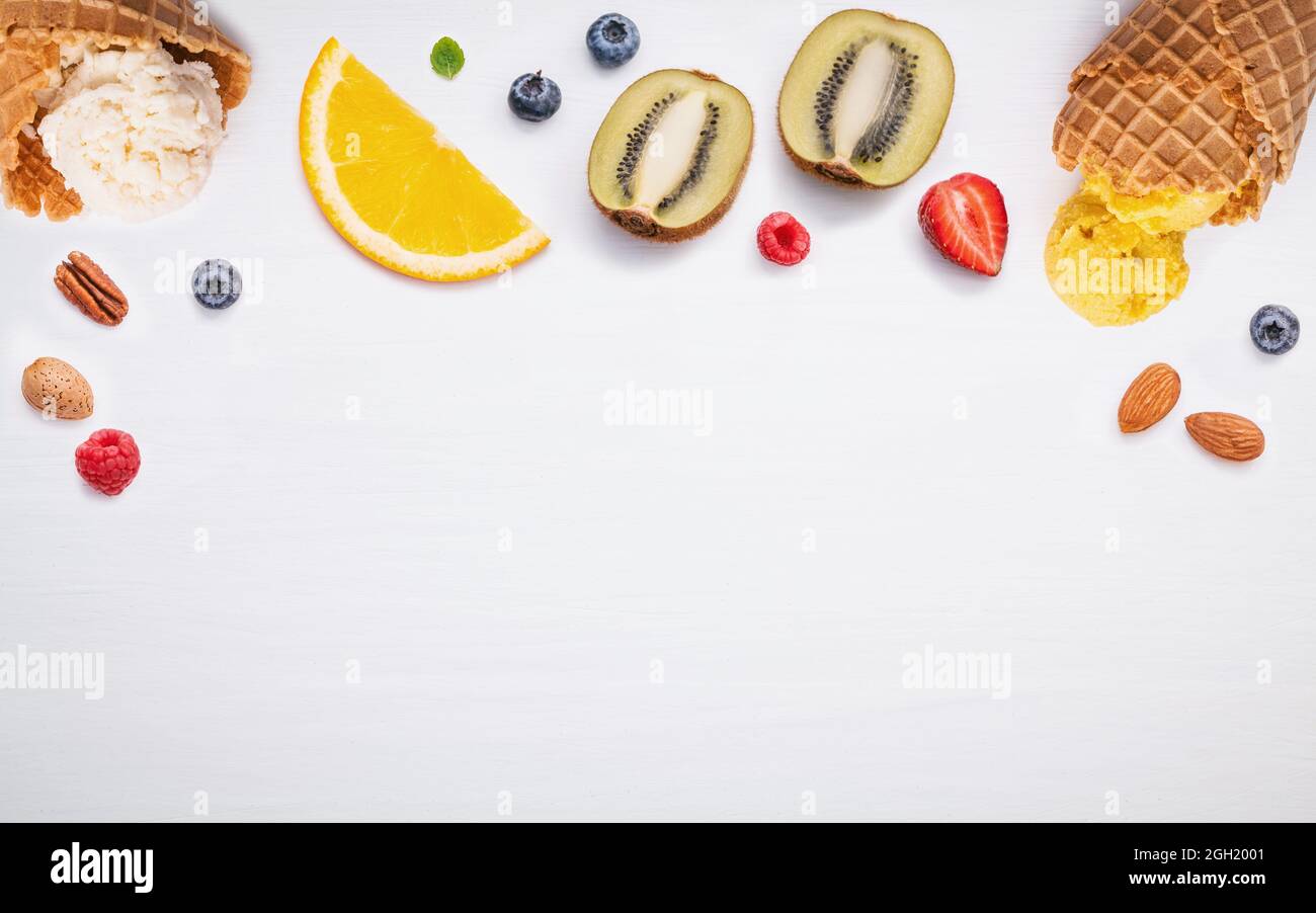 Kegel und bunten verschiedene Früchte Himbeere, Heidelbeere, Erdbeere, Orange Slice, halbieren, Kiwi, Apfel, Tomate und Pfefferminze Blätter setup auf weißen Hinterg Stockfoto