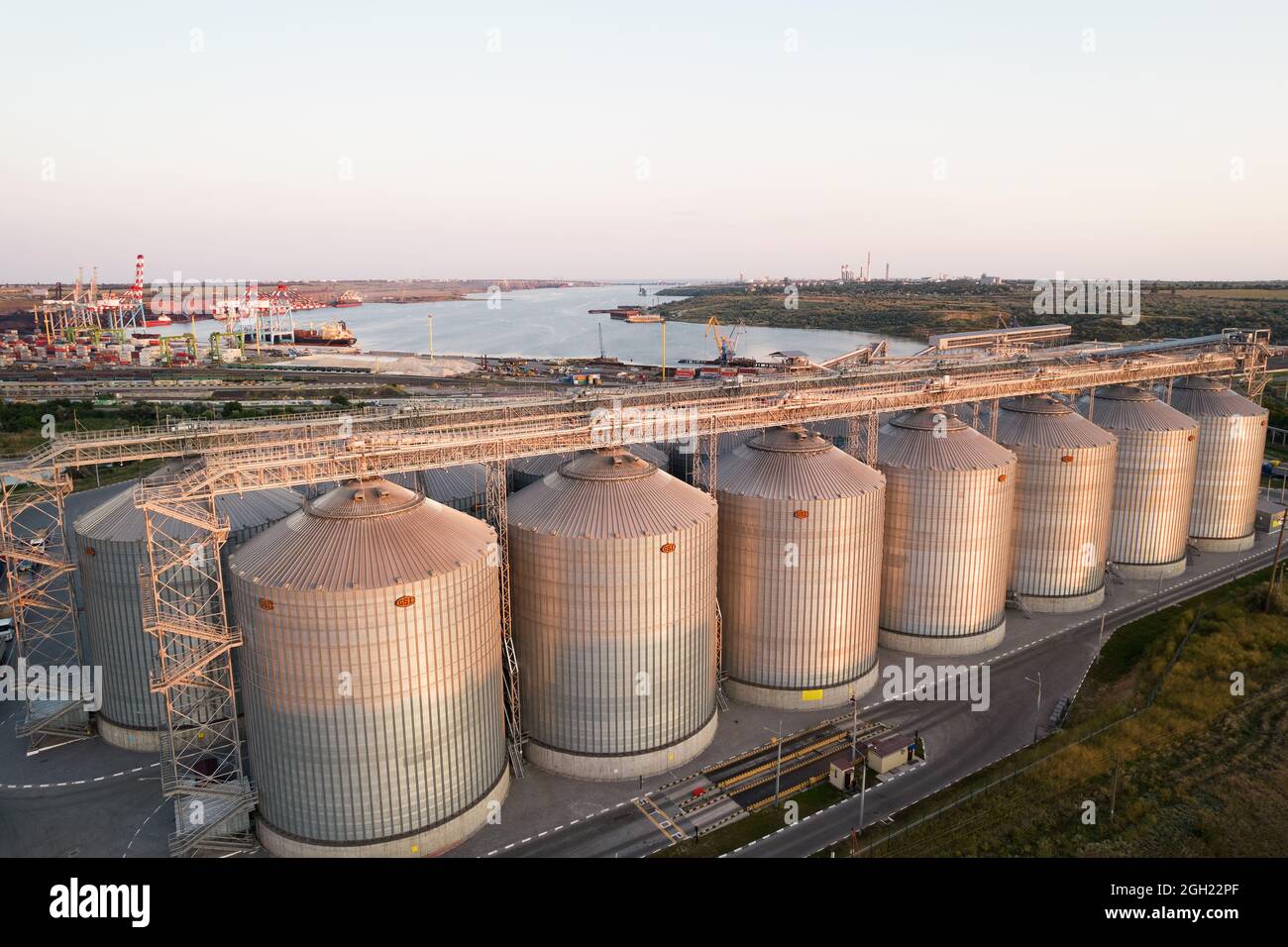 Odessa, Ukraine - Аugust 14, 2021: Getreideterminals des modernen Handelshafens. Silos zur Lagerung von Getreide in Strahlen untergehenden Sonnenlichtes, Draufsicht von Quadco Stockfoto