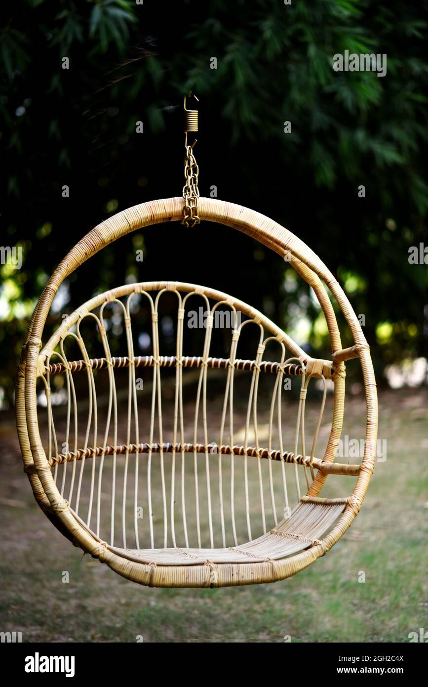 Flügelstuhl im Garten mit einer halbrunden Form aus Korbgeflecht Foto Stockfoto