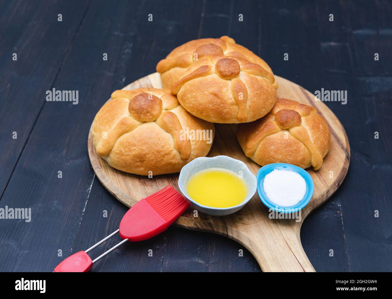 Pan de Muerto auf Holzbrett auf dunklem Hintergrund. Speicherplatz kopieren. Tag der Toten. Mexikanischer Urlaub. Mexikanisches Essen. Stockfoto