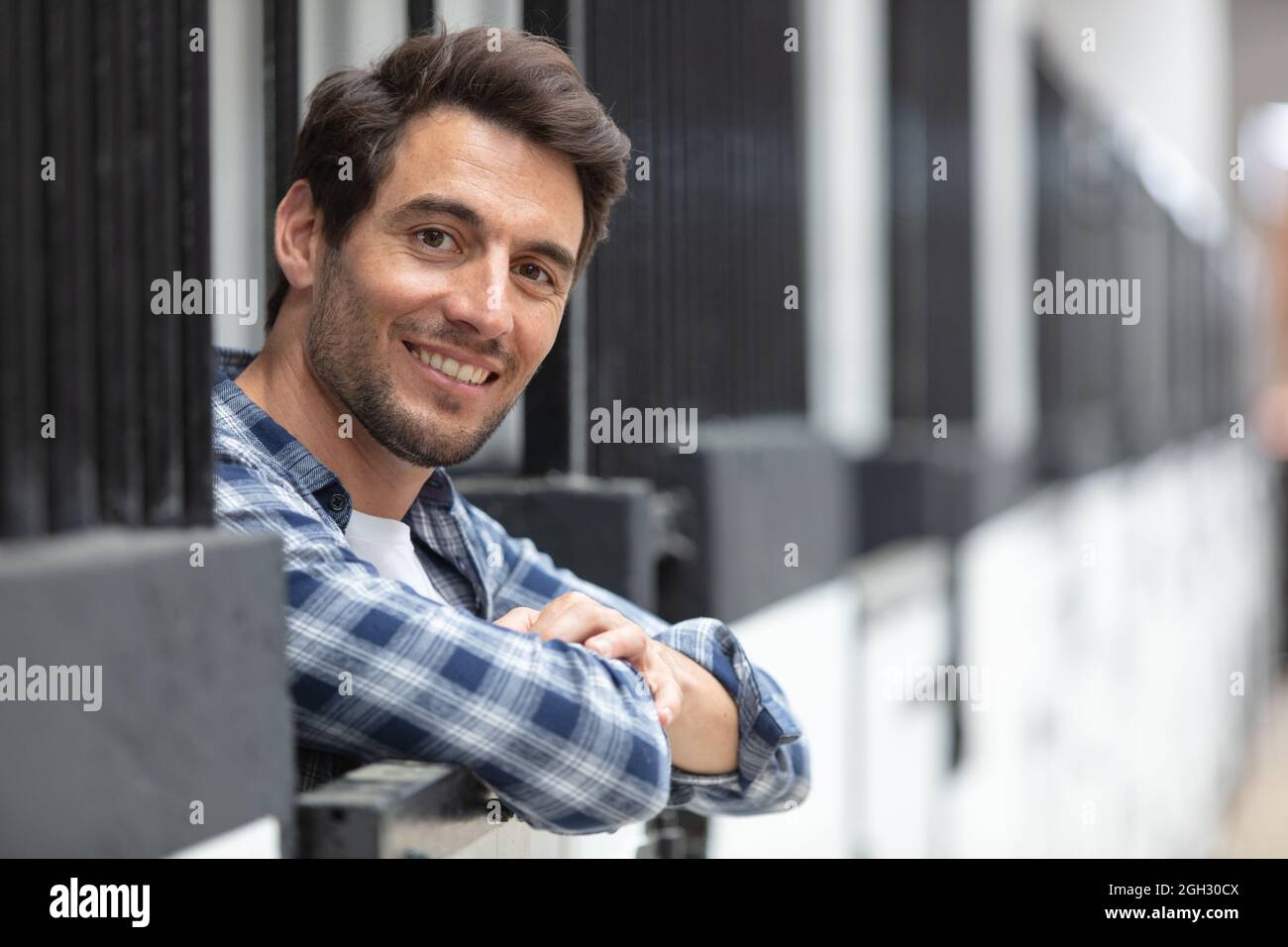 Glücklicher Mann in Casualwear entspannend im Landhaus Stockfoto