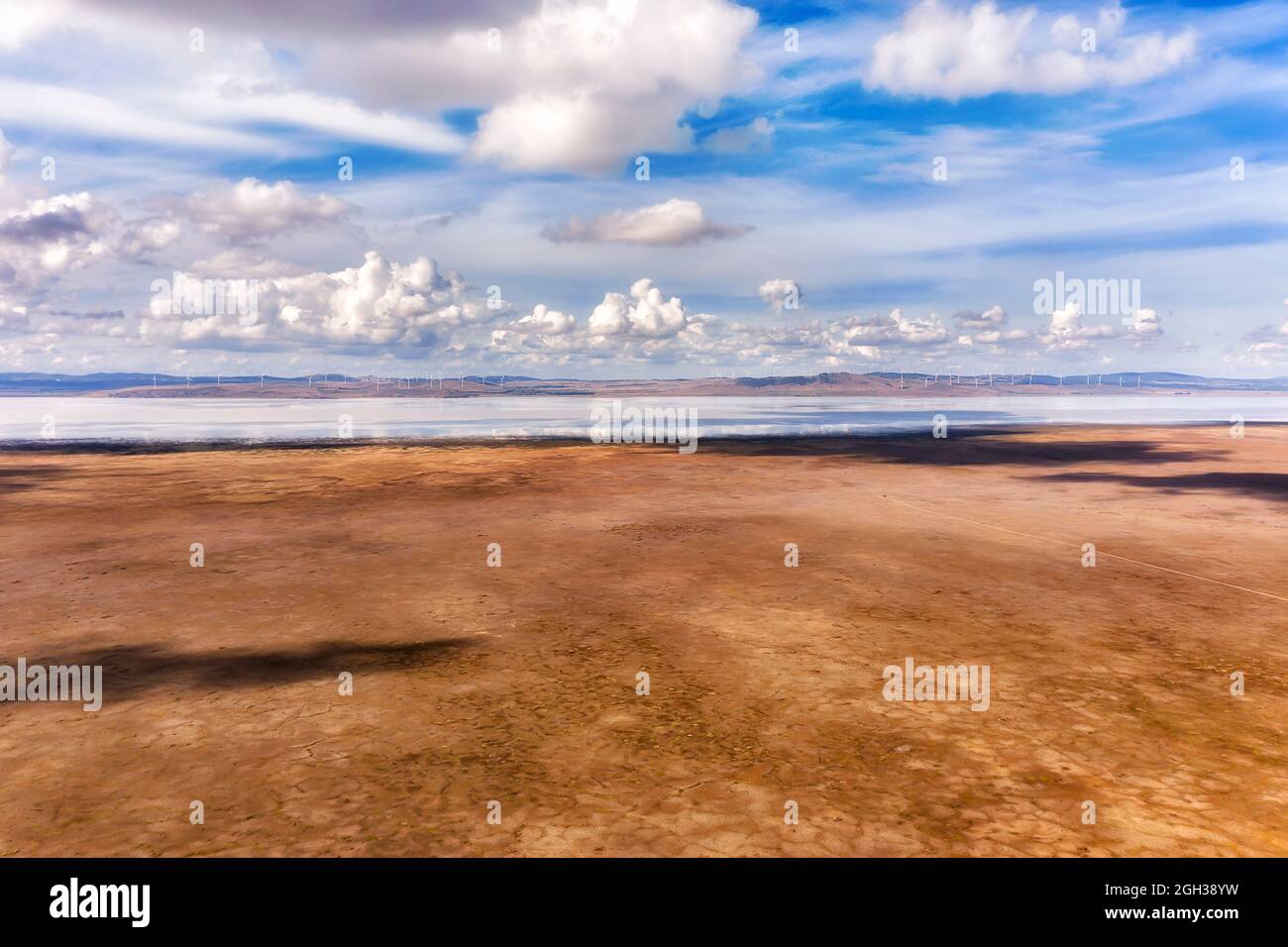Die Ebenen des Lake George in NSW von Australien mit weit entfernten Windfarm-Windmühlen, die erneuerbare Energie erzeugen - landschaftlich reizvoller Blick. Stockfoto