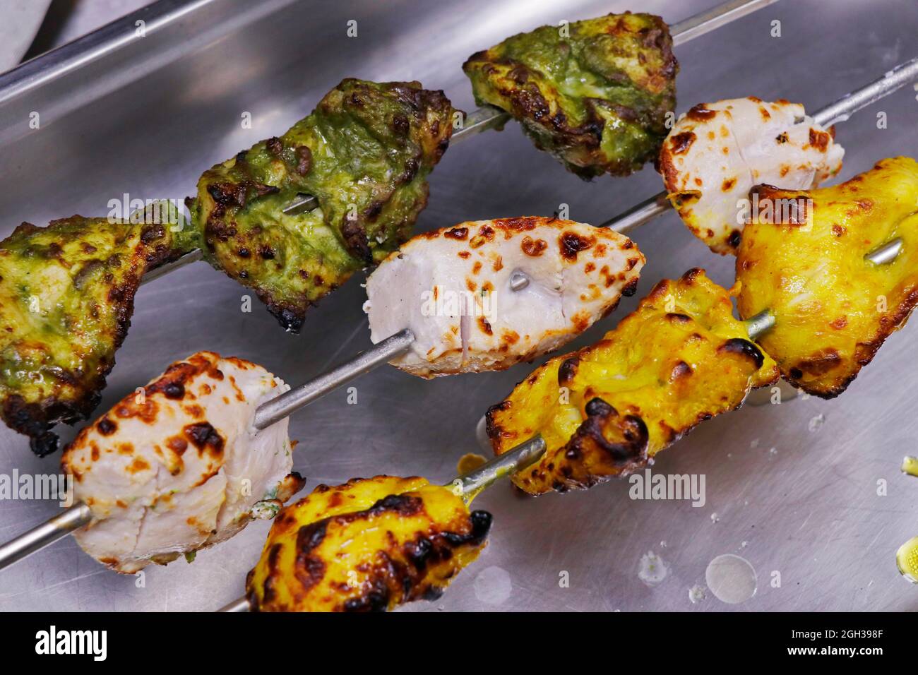 Multi aromatisierte marinierte Tandoori Chicken Tikka Spieß, enthält Malai, Hariyali und Safran Kebab Stockfoto