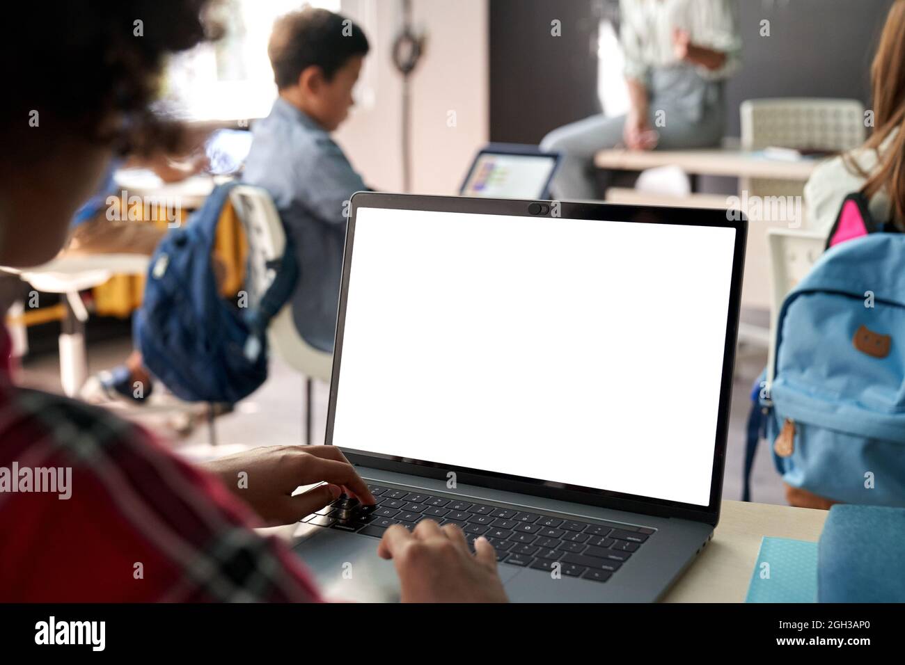 Afroamerikanisches Schulmädchen mit Laptop-Computer mit weißem Mockup-Bildschirm. Stockfoto