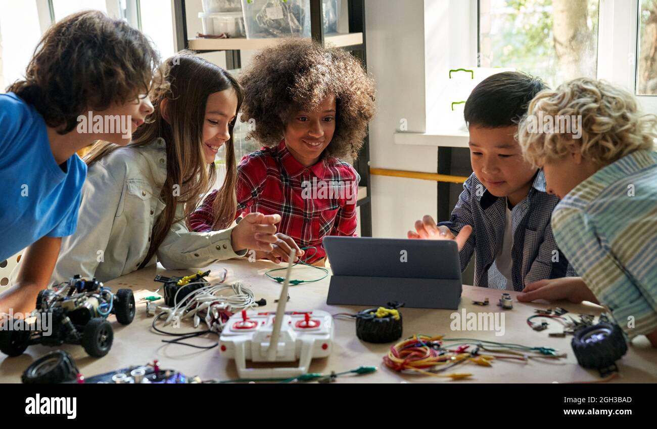 Glückliche Schüler Schüler, die Roboter-Autos mit dem Computer bauen. Stockfoto