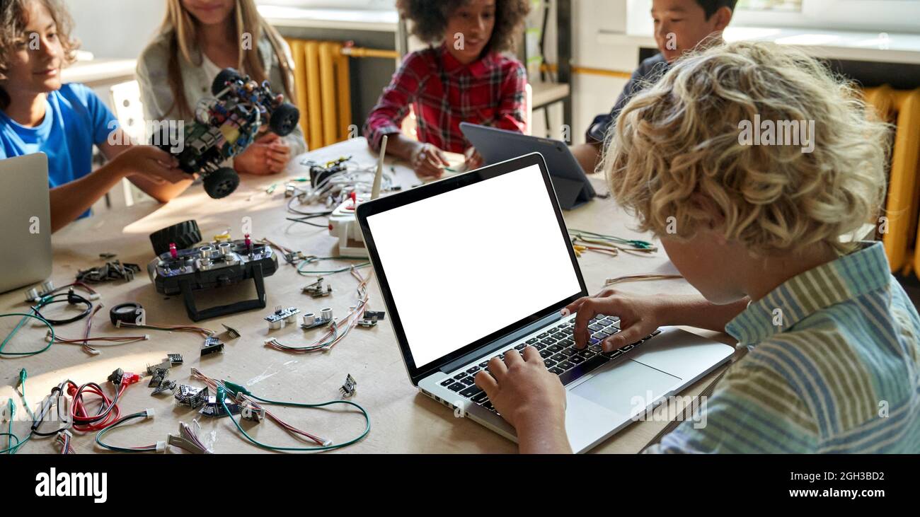 Schuljunge mit Laptop-Computer mit Mockup-Bildschirm in der MINT-Klasse sitzen. Stockfoto