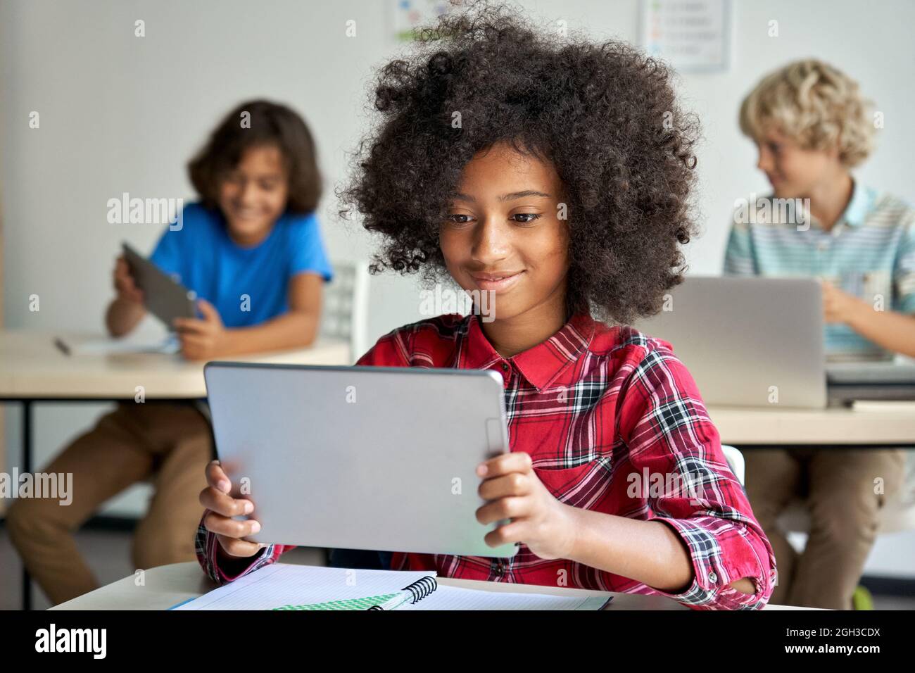 Glückliche afrikanische Schulmädchen mit digitalen Tablet-Computer in der Klasse im Klassenzimmer. Stockfoto