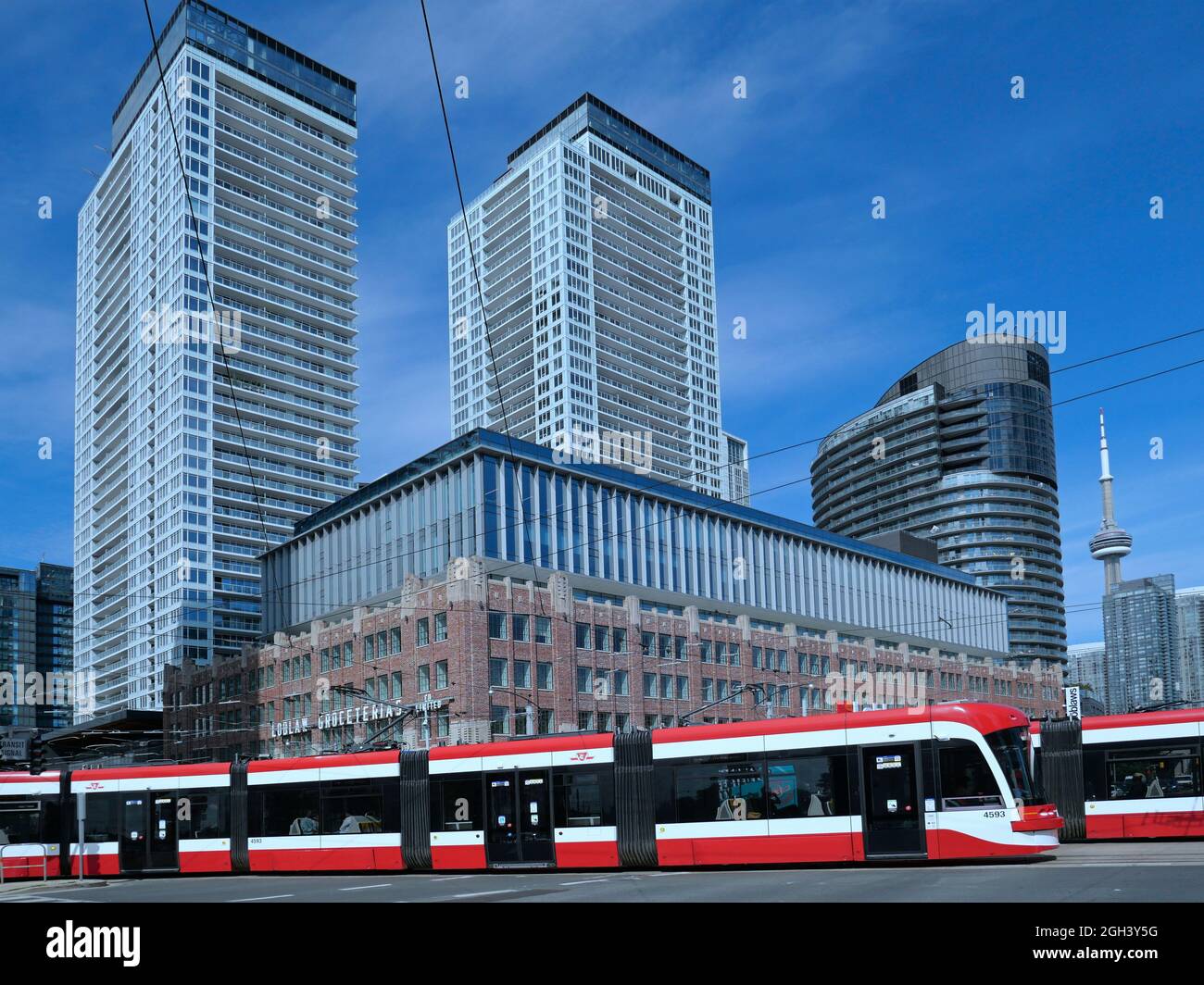 Toronto, Kanada - 3. September 2021: Eine moderne artikulierende Straßenbahn oder Straßenbahn biegt um eine Ecke, mit Hochhäusern in der b Stockfoto