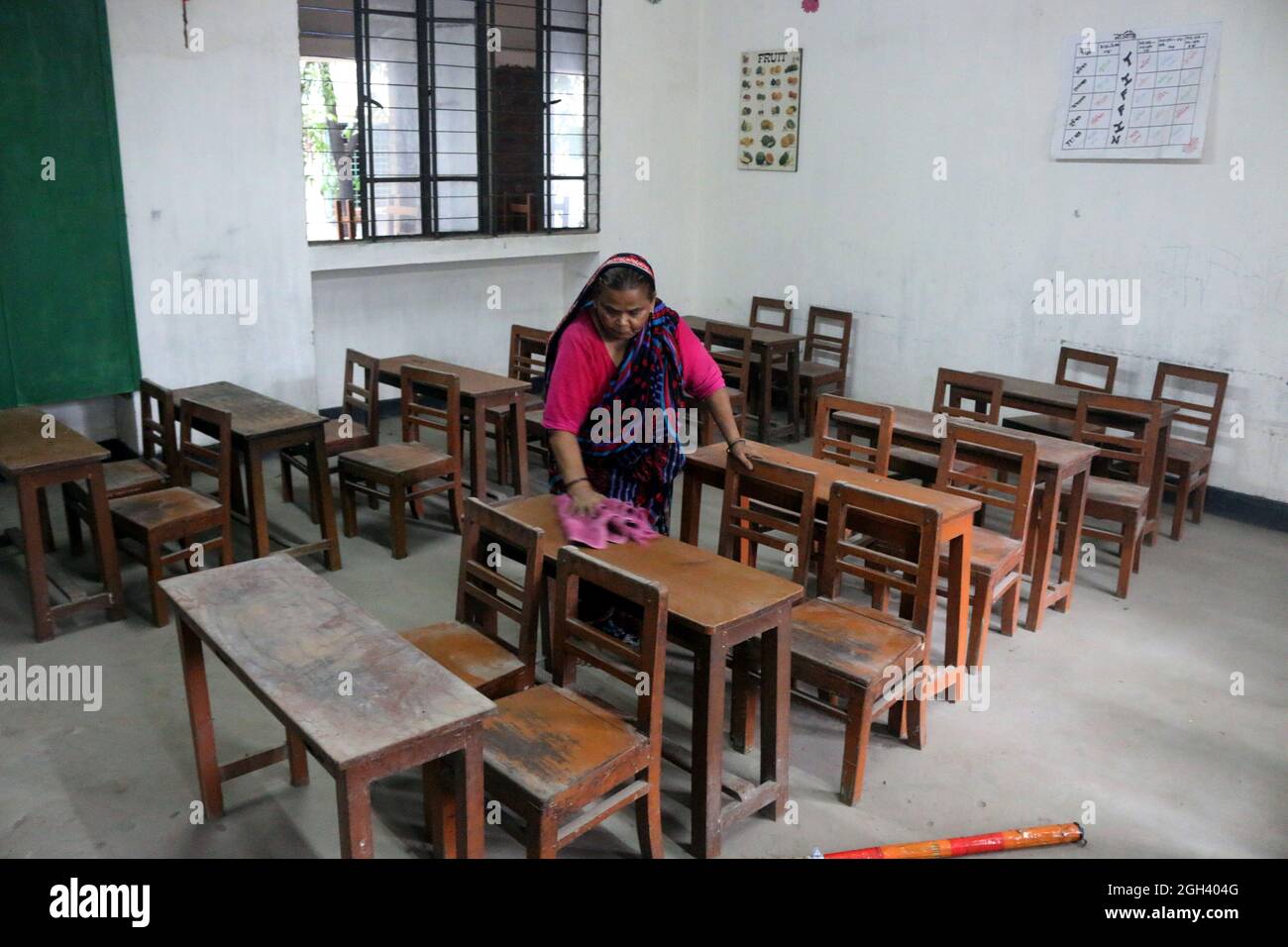 Eine Frau putzt in einem Schulklassenzimmer, als Gesundheitsmaßnahme, bevor sie wieder in die Schule geht. Nach 18 Monaten beschloss die Regierung von Bangladesch, dass alle Schulen ab dem 12. September, während der Coronavirus-Pandemie, wieder eröffnet werden. Am 4. September 2021 in Dhaka, Bangladesch. (Foto von Habibur Rahman / Eyepix Group) Stockfoto