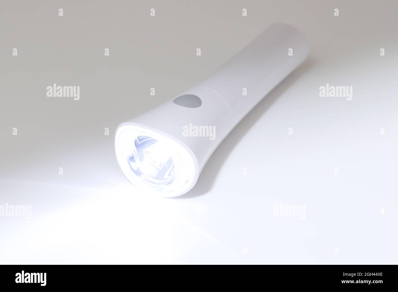 Elektrische LED-Taschenlampe und Lichtstrahl auf dunklem Hintergrund Stockfoto