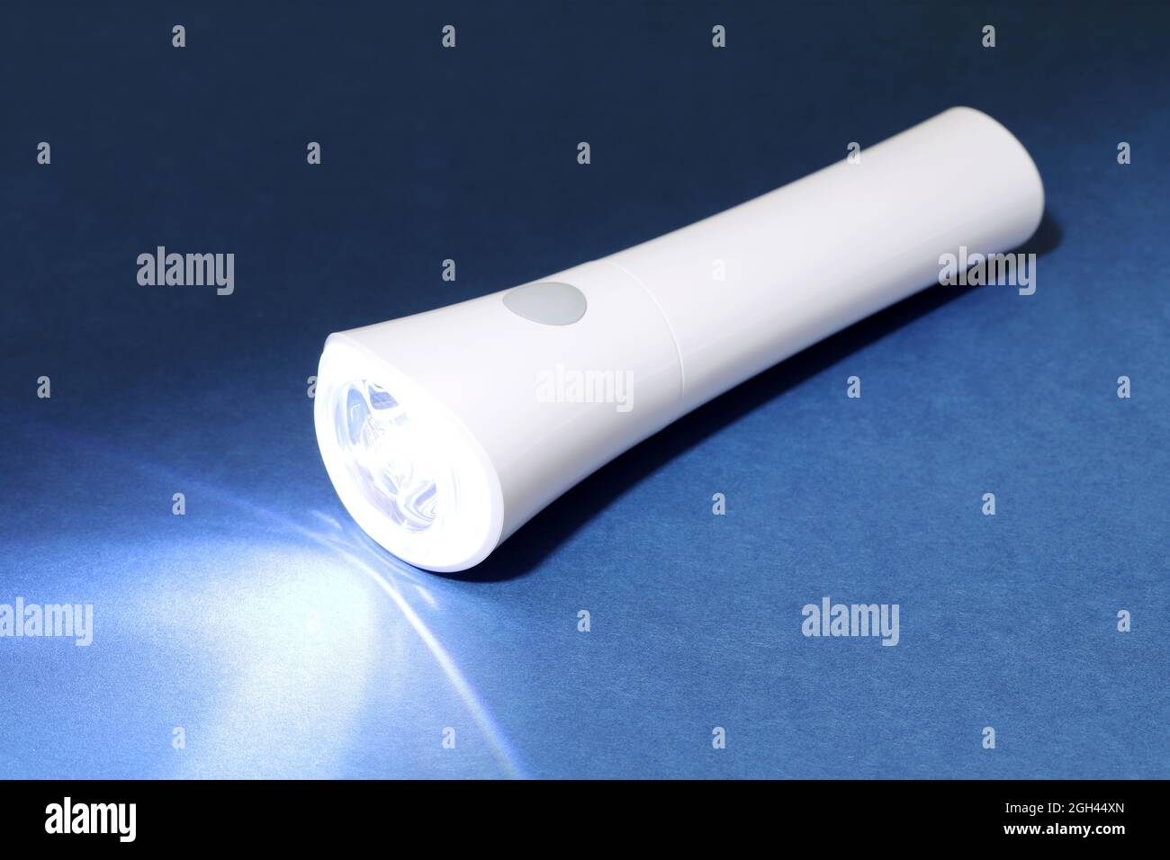 Elektrische LED-Taschenlampe und Lichtstrahl auf dunklem Hintergrund Stockfoto