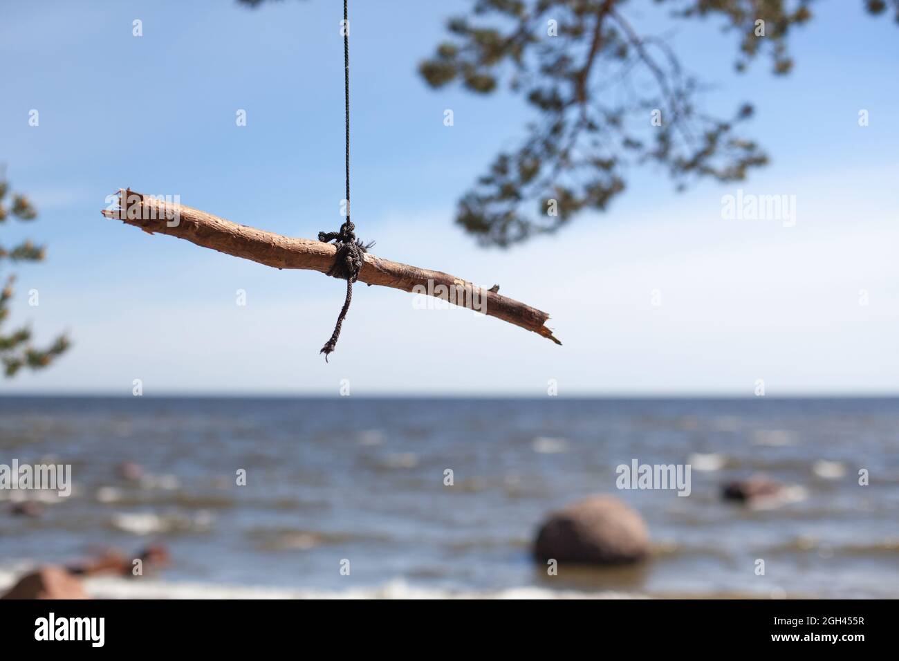 Primitive Schaukel, ein Stock, der an einem Seil hängt, das an einem Ast hängt Stockfoto