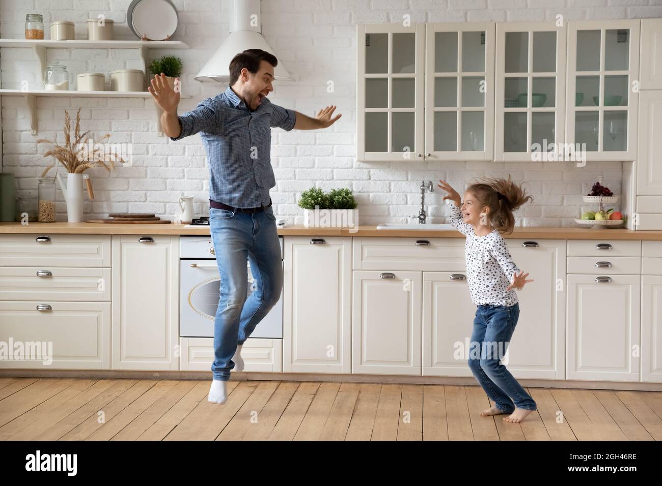 Aufgeregt verrückt Papa Lehre Tochter Mädchen zu Hause tanzen Stockfoto