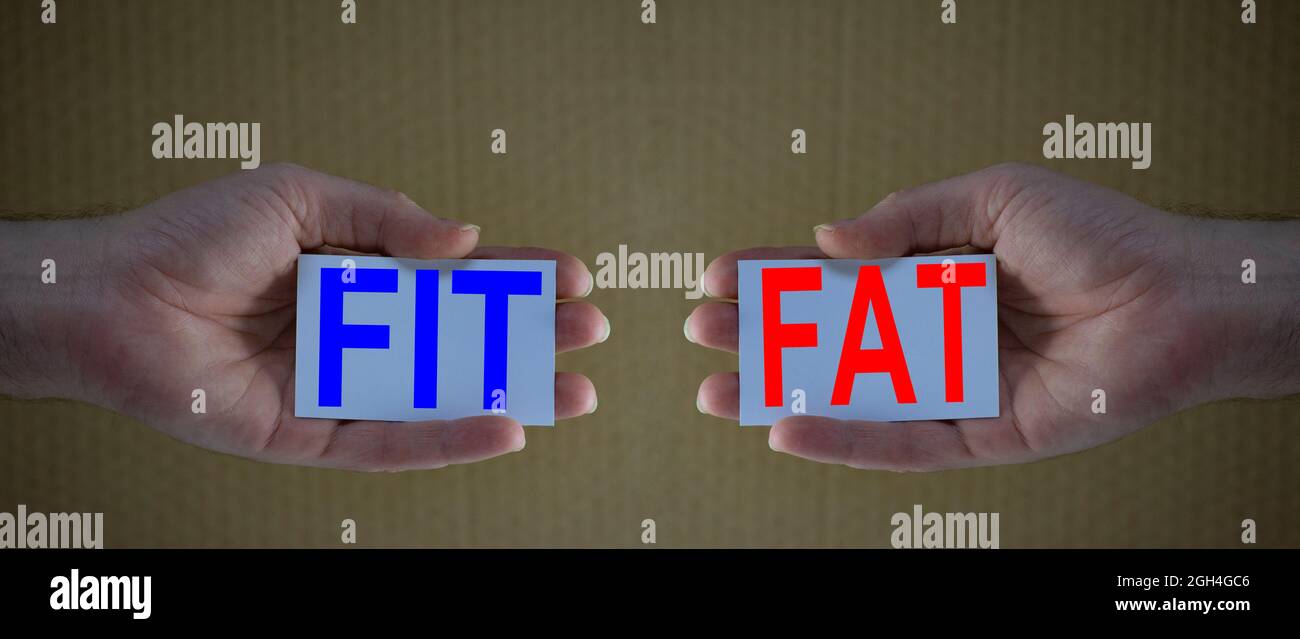 Fit and Fat kreatives Konzept: Mann Hände halten Karten mit den Worten FIT und FETT. Konzept für gesunden Lebensstil, Fitness, Sport, Ernährung und Körper po Stockfoto