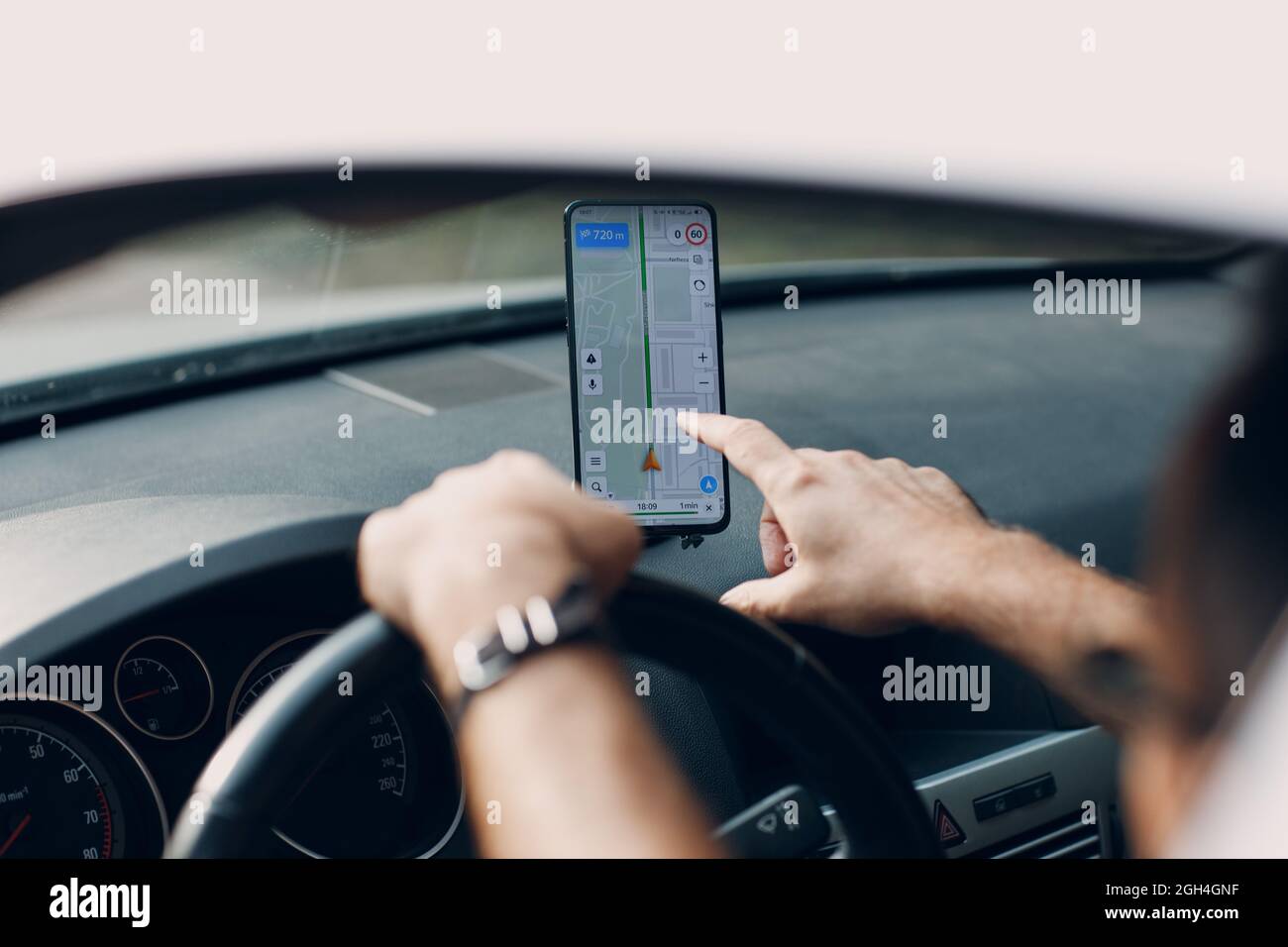 Navigator im Pkw-Transport Pendler. Fahrer, der während der Fahrt mit dem Auto die Handy-Navigator-App verwendet. Stockfoto