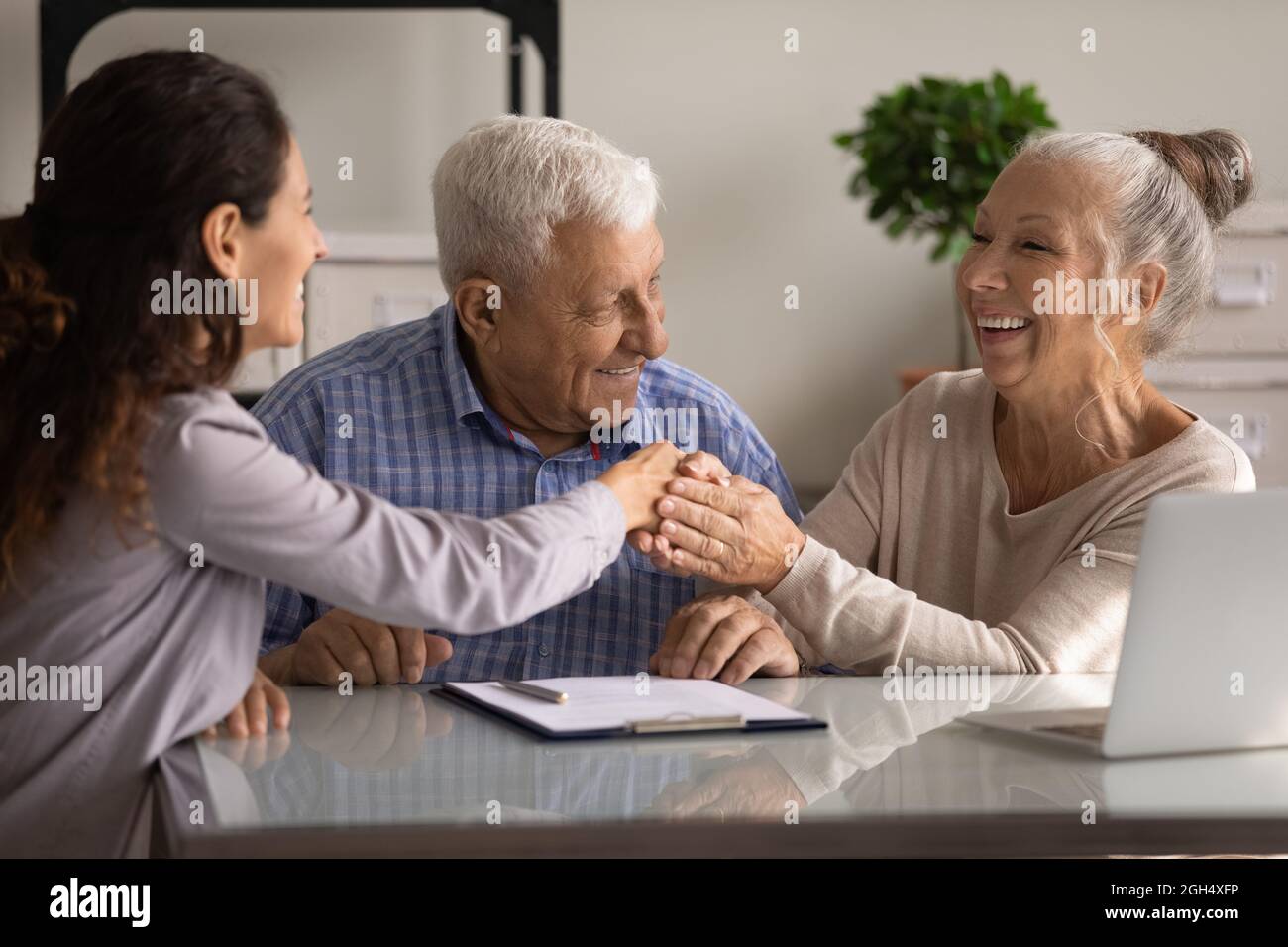 Glückliches Senior-Paar von Kunden, die sich mit einem Immobilienmakler treffen Stockfoto