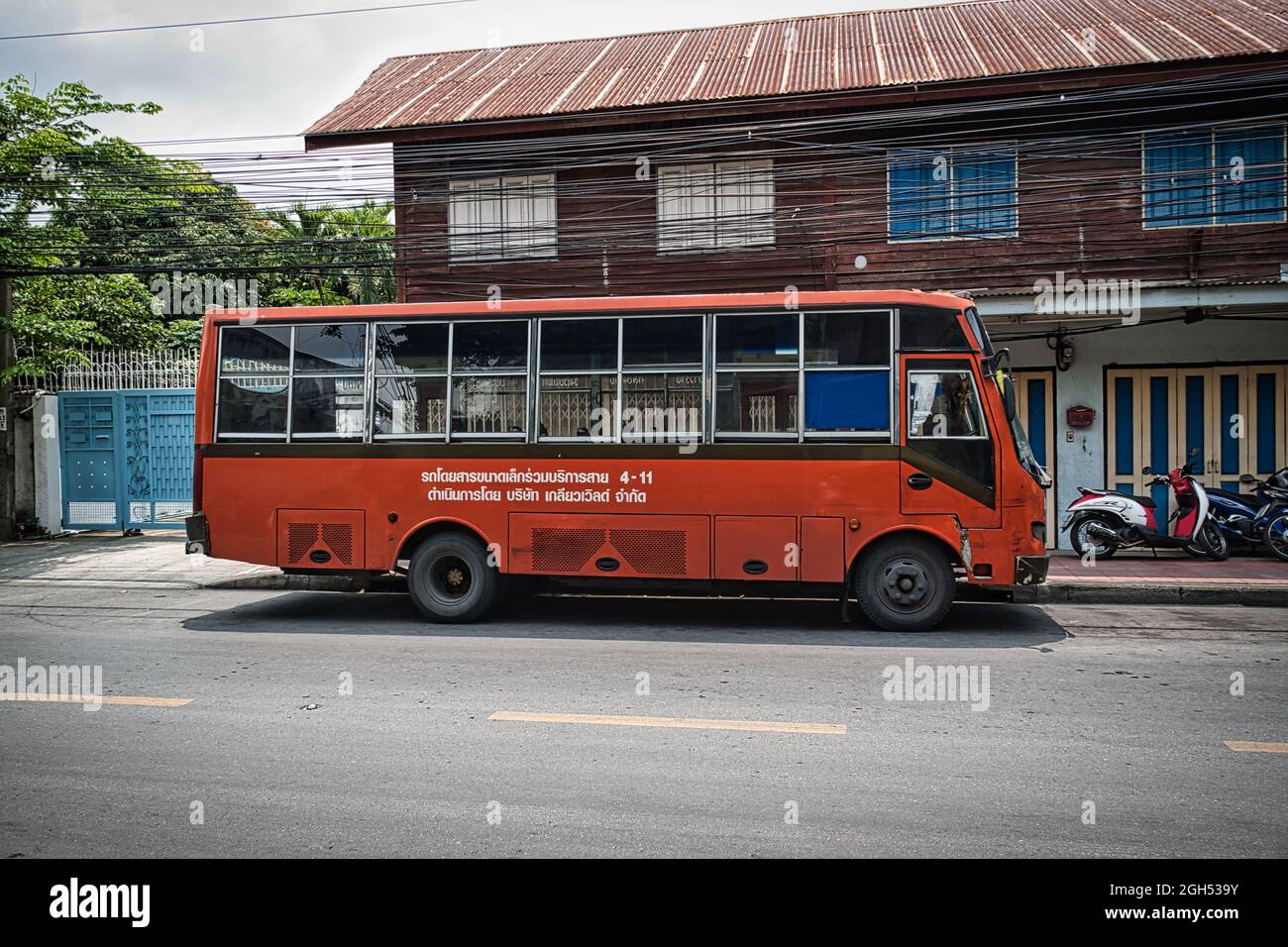 Bangkok, Thailand 04.28.2021 Old orange Retro Bus Parkplatz auf der Seite einer ruhigen Straße von Bangkok Stockfoto