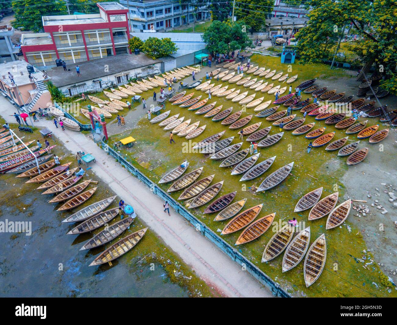 Luftaufnahme von Personen aus Savar und Aminbazar, die am Markt ankommen, um Boote zu kaufen, um sie in ländlichen Gebieten während der Monsunsaison zu benutzen, wenn starker Regen Dörfer und Straßen überflutet, der Preis der Boote ist von BDT 1,500 bis BDT 5,000 (nationale Währung) Je nach Größe und Qualität der verwendeten Materialien. Die Nachfrage nach Dingi und Khosa Nauka (Kleinboot) ist für den Transport von Menschen in hochwassergefährdeten Gebieten gestiegen. Der Markt ist bekannt für den Verkauf von handgefertigten Booten jeden Mittwoch in den letzten 50 Jahren von Juni bis Oktober. Am 5. September 2021 in Manikganj, Bangladesch. (P Stockfoto