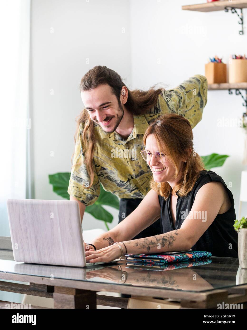 Kreative Designer und Designerinnen zeichnen Skizzen auf grafischen Tablets, während sie gemeinsam an einem Projekt im Arbeitsbereich arbeiten Stockfoto