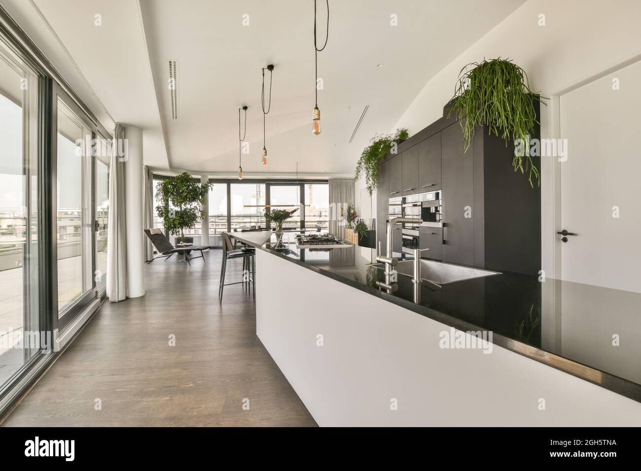 Esstisch und Stühle in der Nähe offene Küche in modernen Loft-Stil Wohnung  mit weißen Wänden und Decke in geräumigen Wohnung platziert Stockfotografie  - Alamy